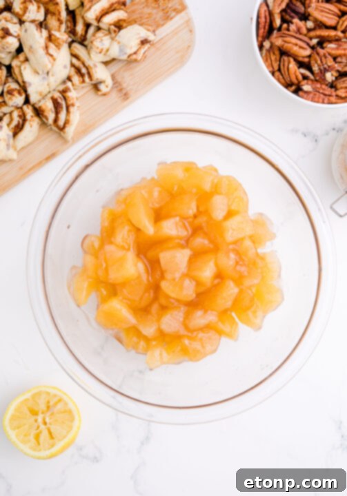 Chopped apple pie filling mixed with lemon juice in a white bowl.