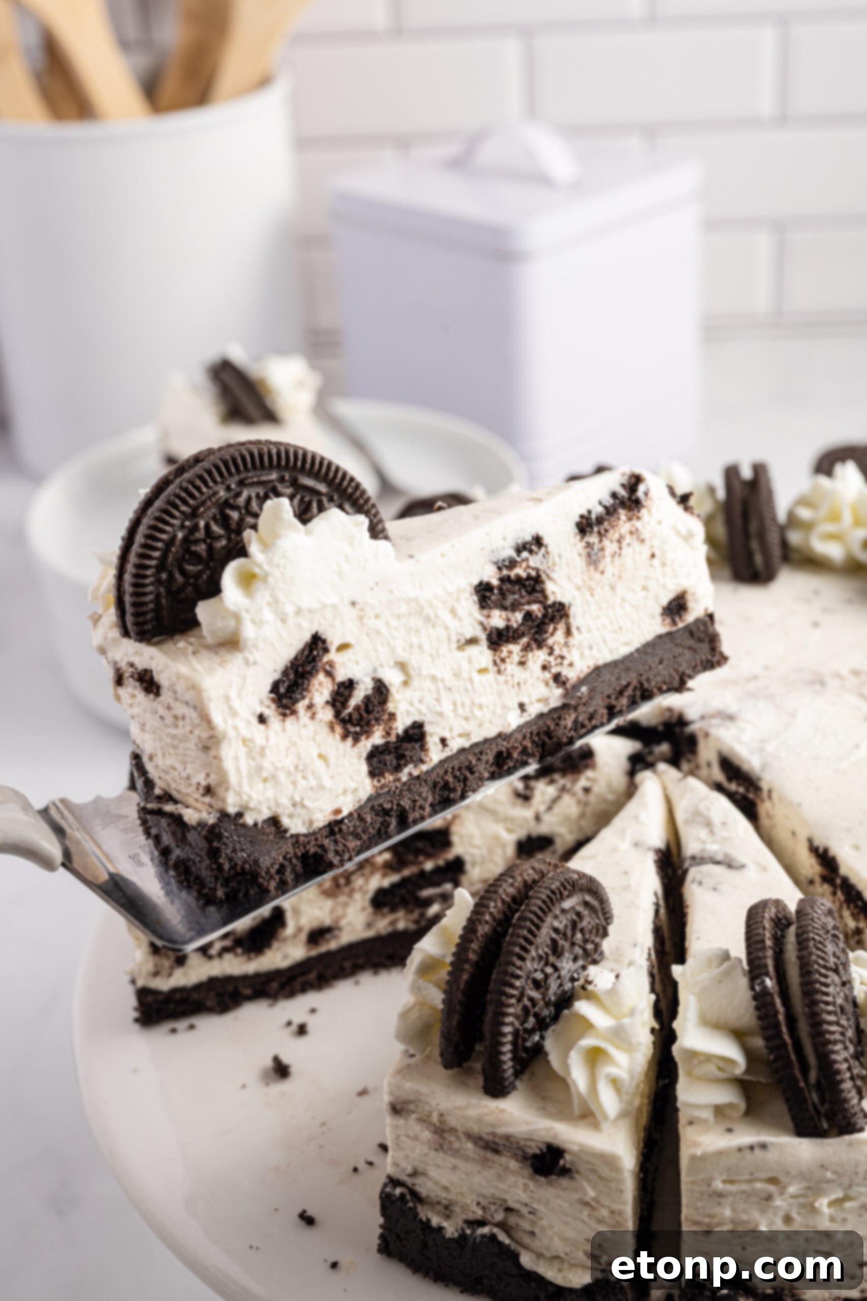 No-Bake Oreo Cheesecake Magic 2 Side view of a perfectly sliced No Bake Oreo Cheesecake on a silver spatula, showcasing its creamy layers and rich Oreo crust.