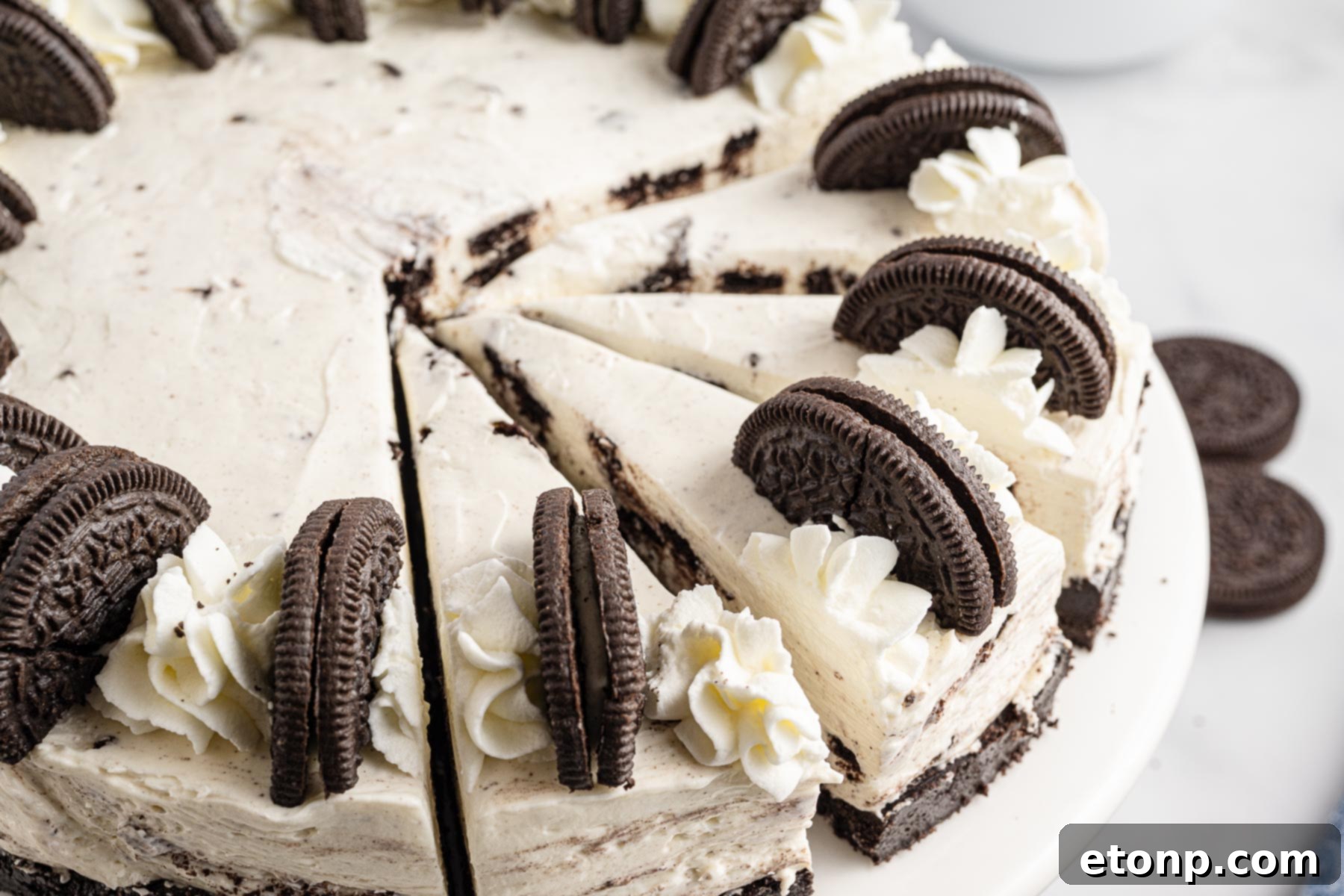 No-Bake Oreo Cheesecake Magic 4 A delectable No Bake Oreo Cheesecake, sliced into numerous pieces, highlighting its rich layers and tempting appearance.