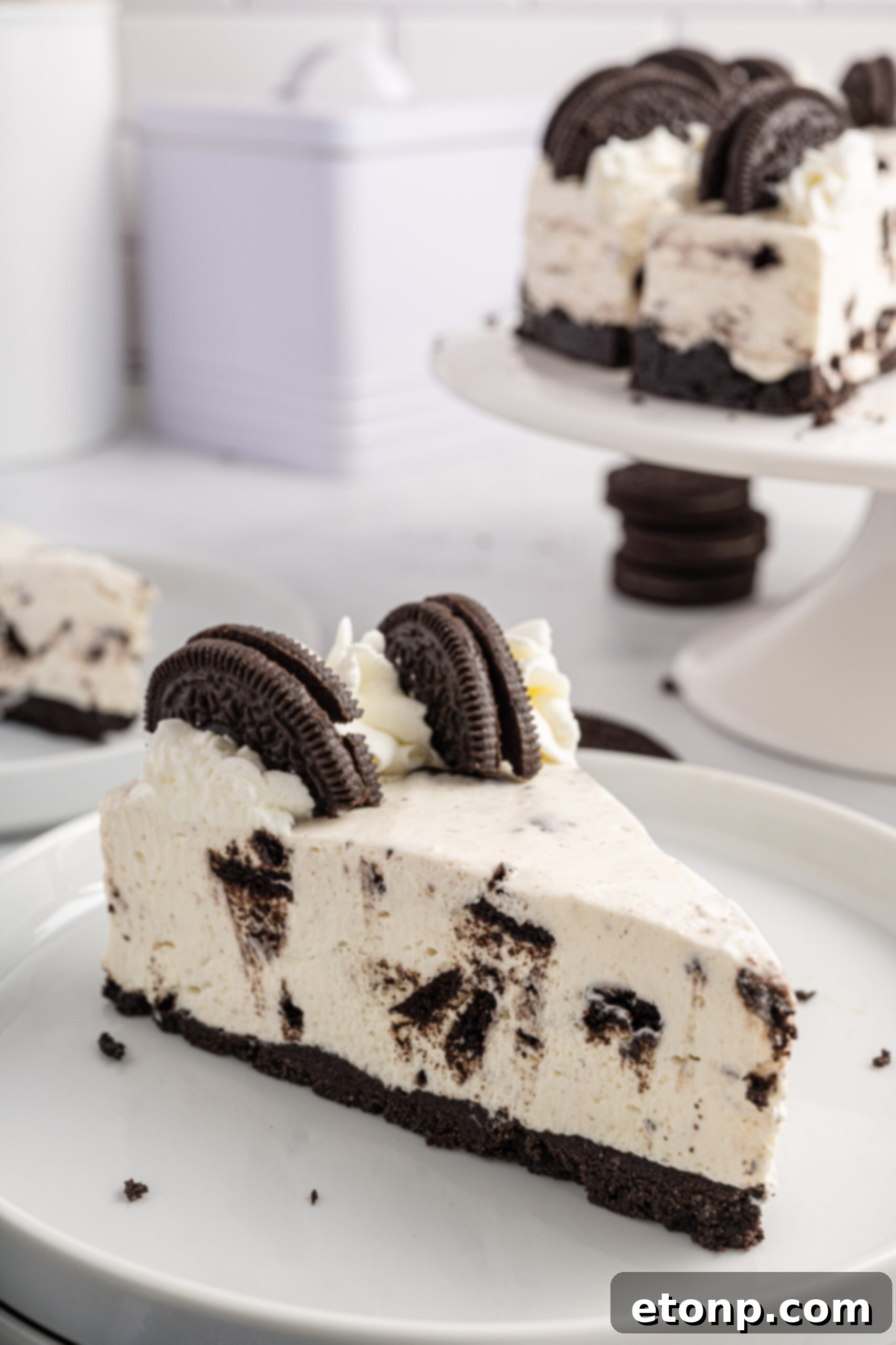 No-Bake Oreo Cheesecake Magic 7 Side view of a generous slice of No Bake Oreo Cheesecake, beautifully plated on a white dish, ready for enjoyment.