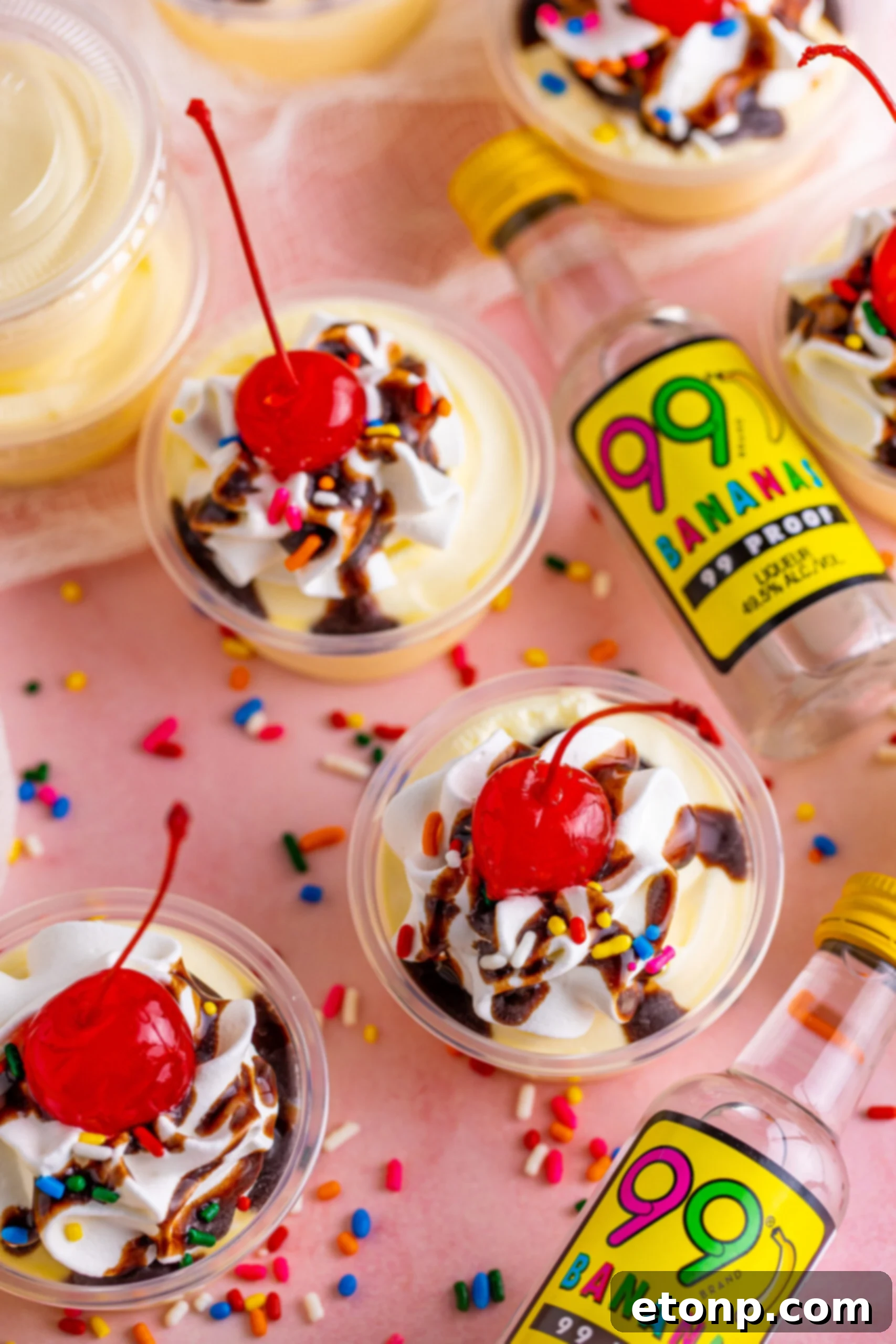 Overhead view of Banana Split Shots surrounded by rainbow sprinkles.