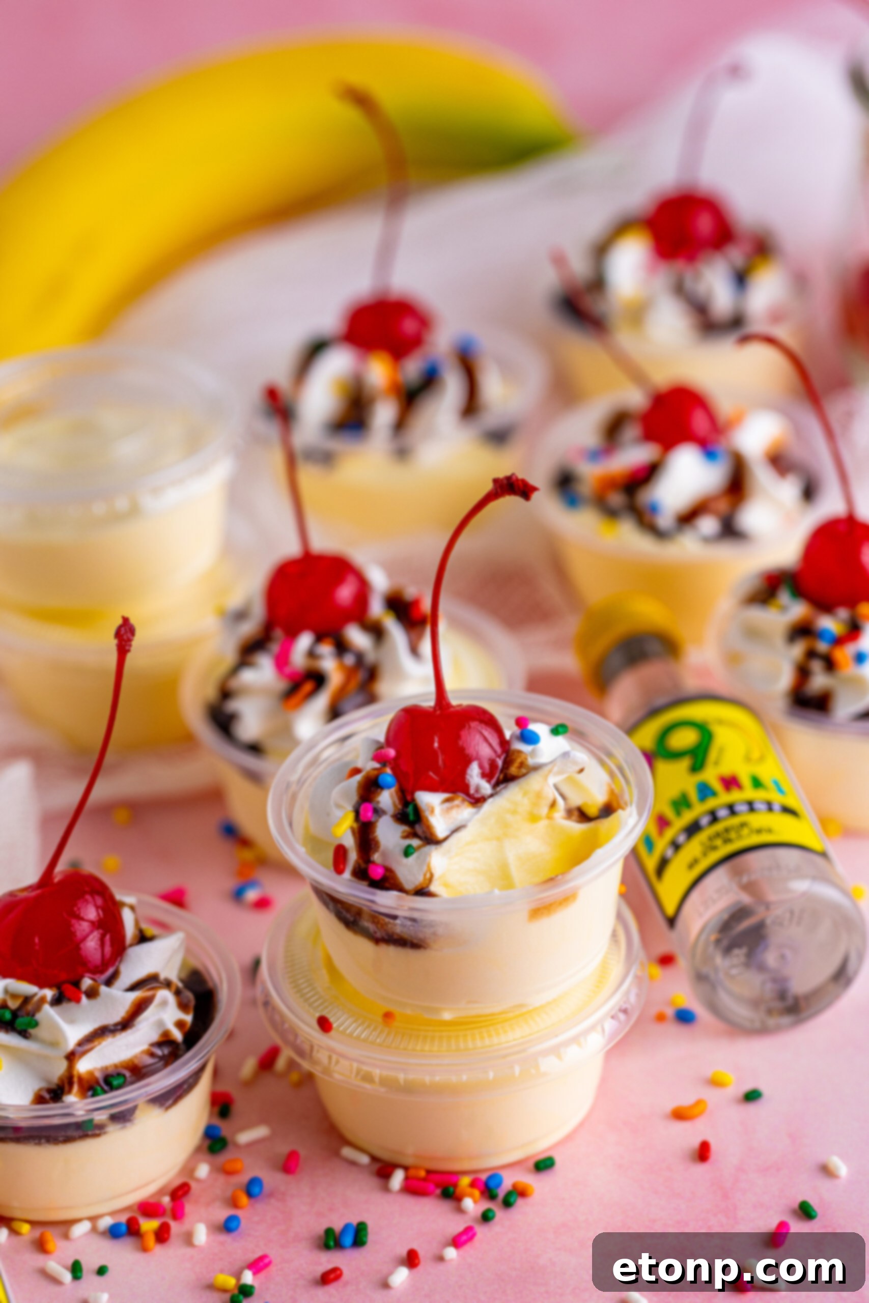 Banana pudding shots stacked surrounded by sprinkles 