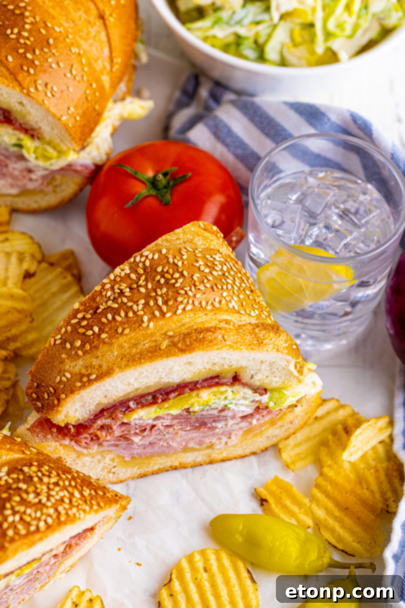 Toasted Grinders 3 45 degree view of perfectly assembled Grinder Subs on parchment paper, ready to serve with a side of crispy chips.