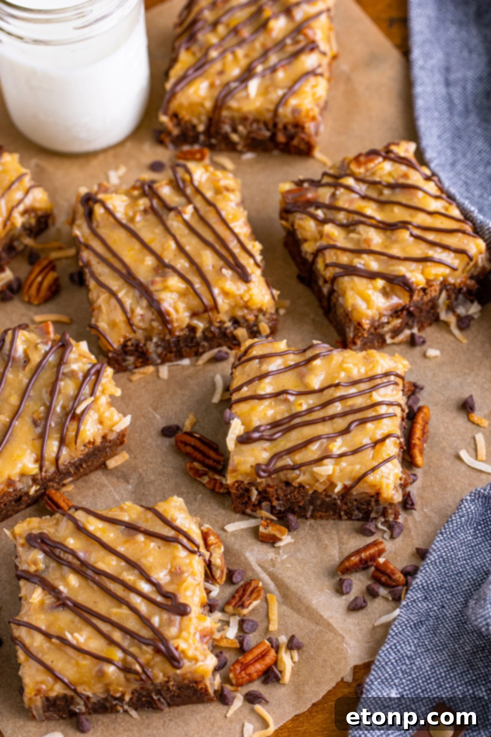 Overhead view of a tray of freshly baked German Chocolate Brownies, still on parchment paper, ready for cutting.