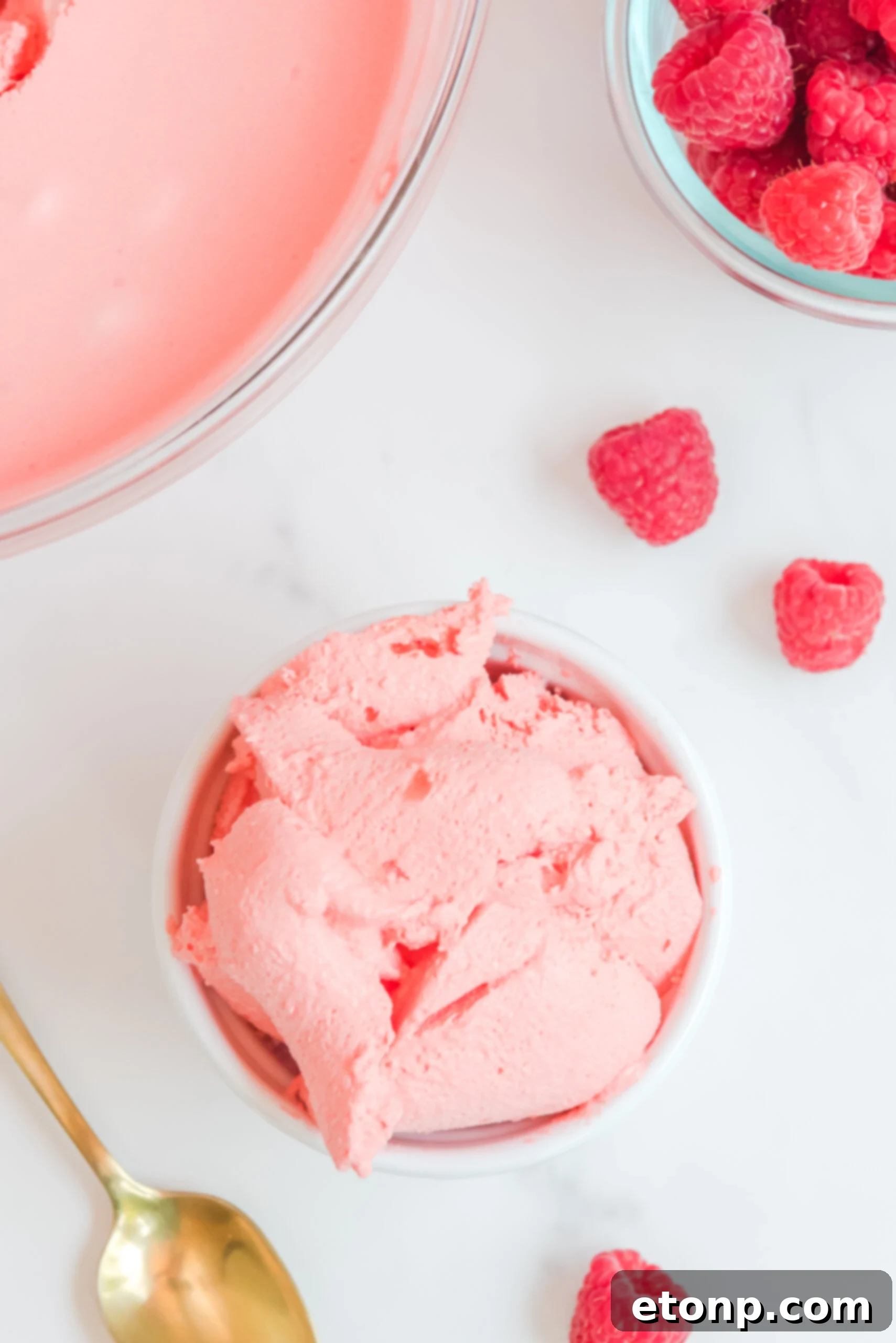 Overhead view of Raspberry Jello Fluff in a single white dish, showing its smooth, creamy texture and light pink hue, ready to be served.