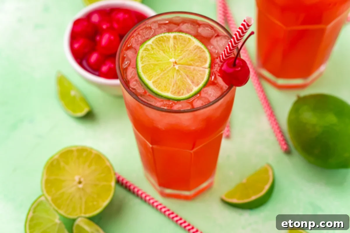 45 degree view of Cherry Limeade garnished with a lime and cherry.