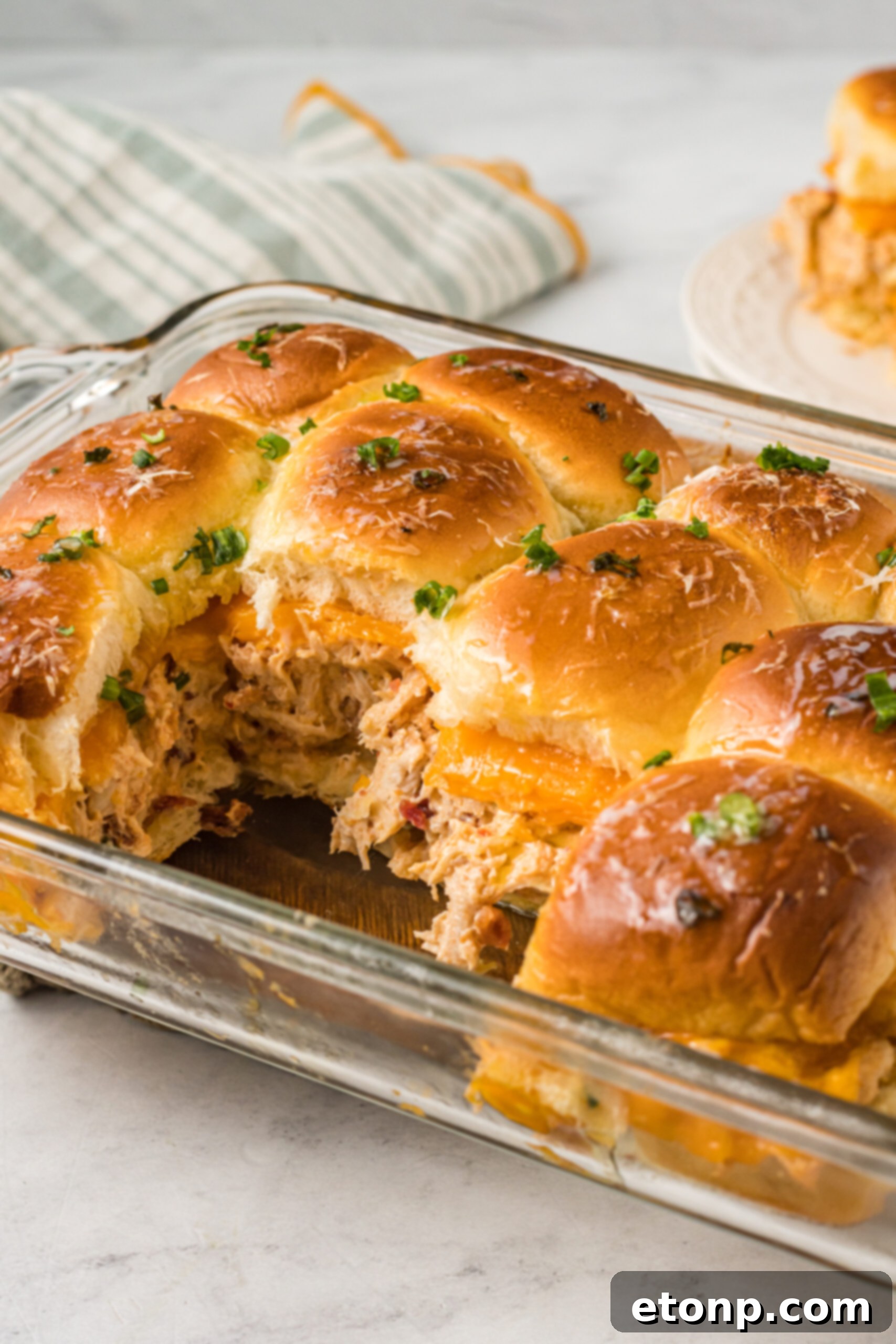 Side view of Crack Chicken Sliders in a clear baking dish.