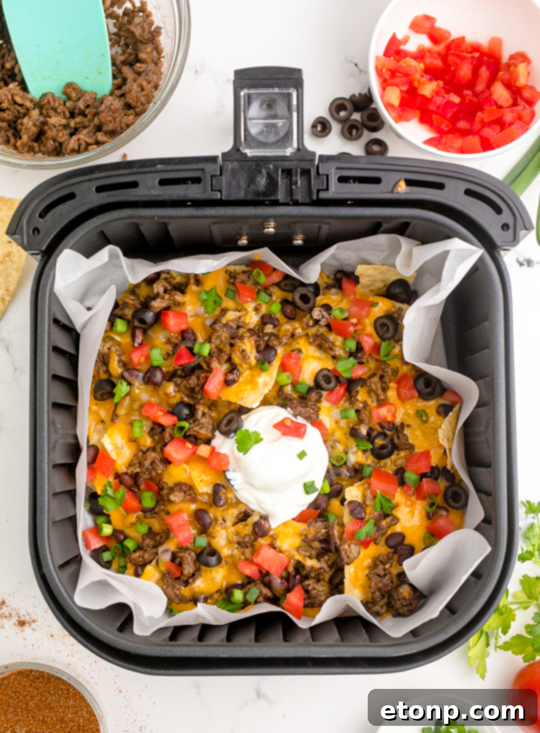 Overhead view of Air Fryer Nachos in an air fryer basket.