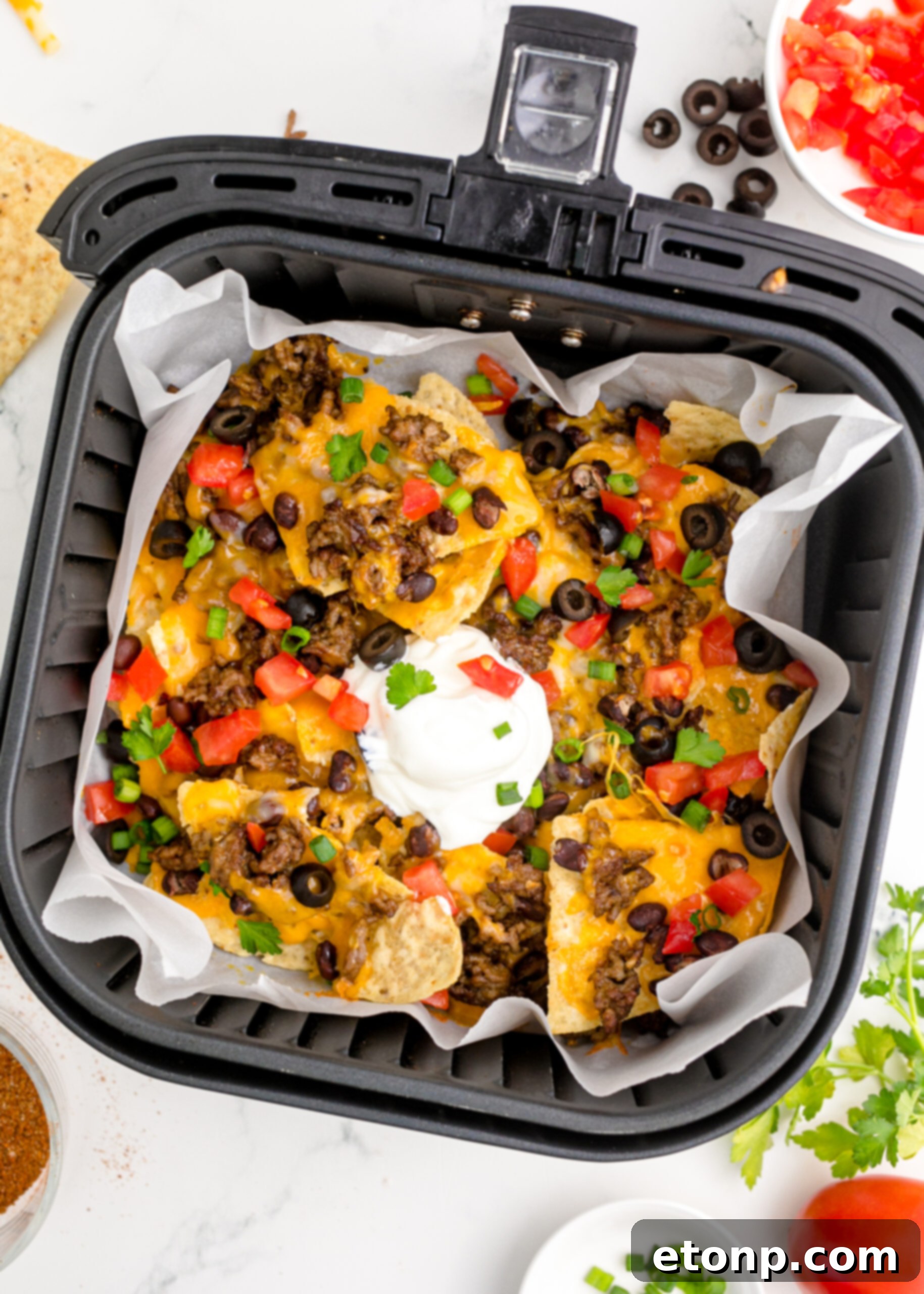 Overhead view of Air Fryer Nachos in an air fryer basket.
