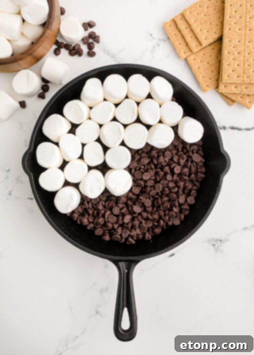 A wider shot showcasing the S’mores Dip in a cast iron skillet, emphasizing its readiness for serving with a rustic charm.