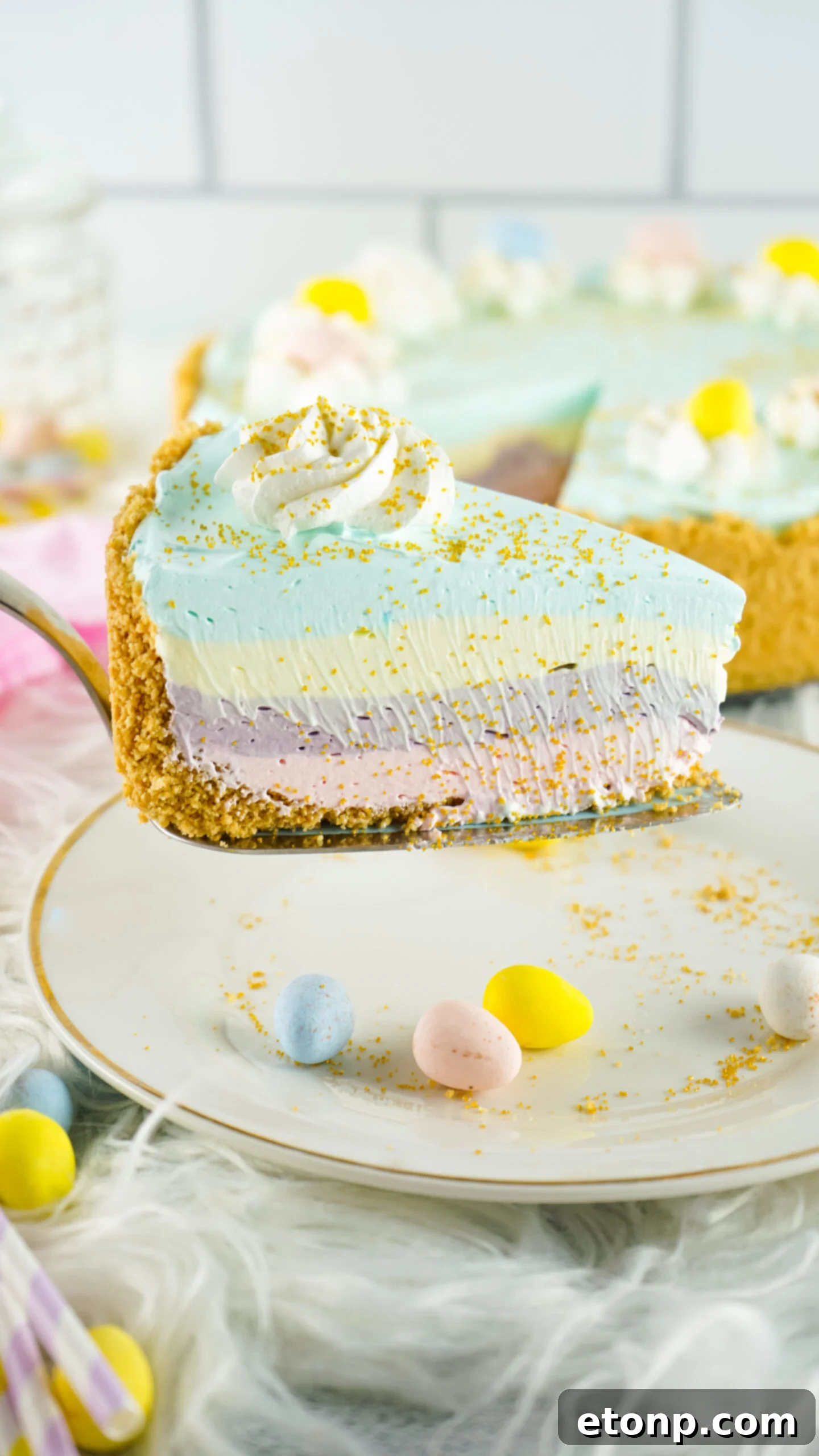 Side view of a slice of Easter Kool Aid Pie on a gold cake server.