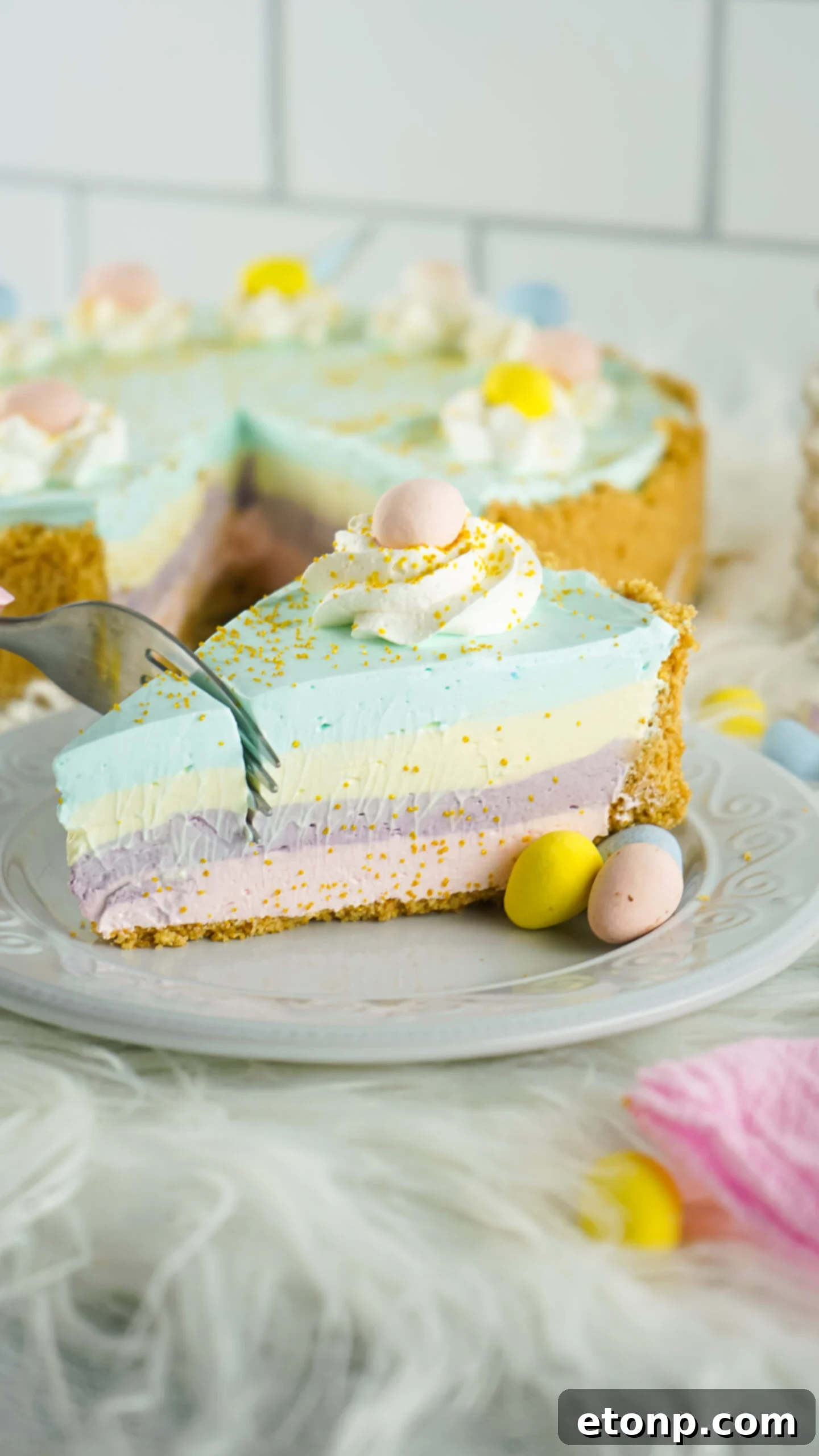 Side view of a slice of Easter Kool Aid Pie with a silver fork removing a bite.
