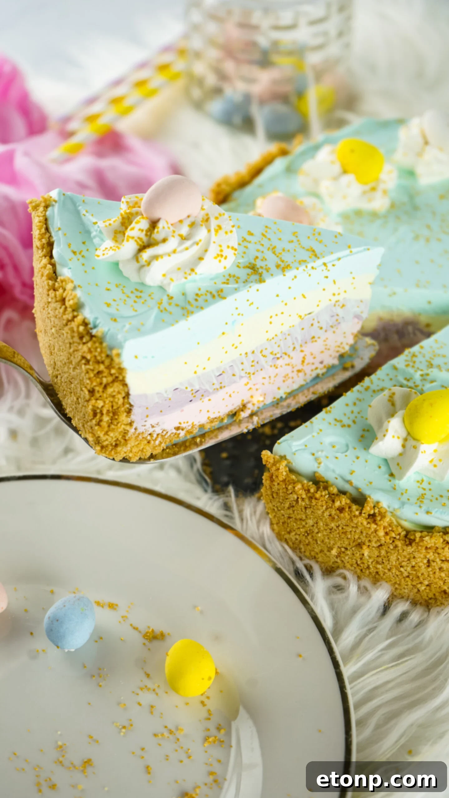 Side view of a slice of Easter Kool Aid Pie on a gold cake server.