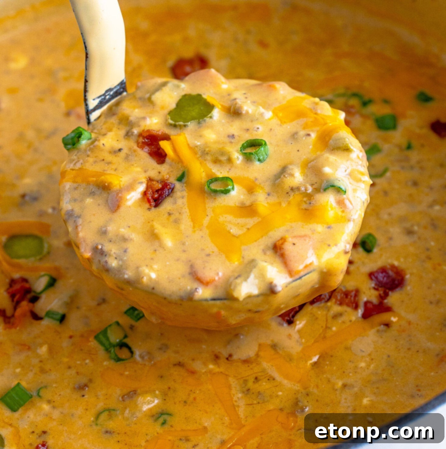 Bacon Cheeseburger Bliss in a Bowl 15 Cheeseburger bacon soup in a large Dutch oven being removed with a silver ladle.