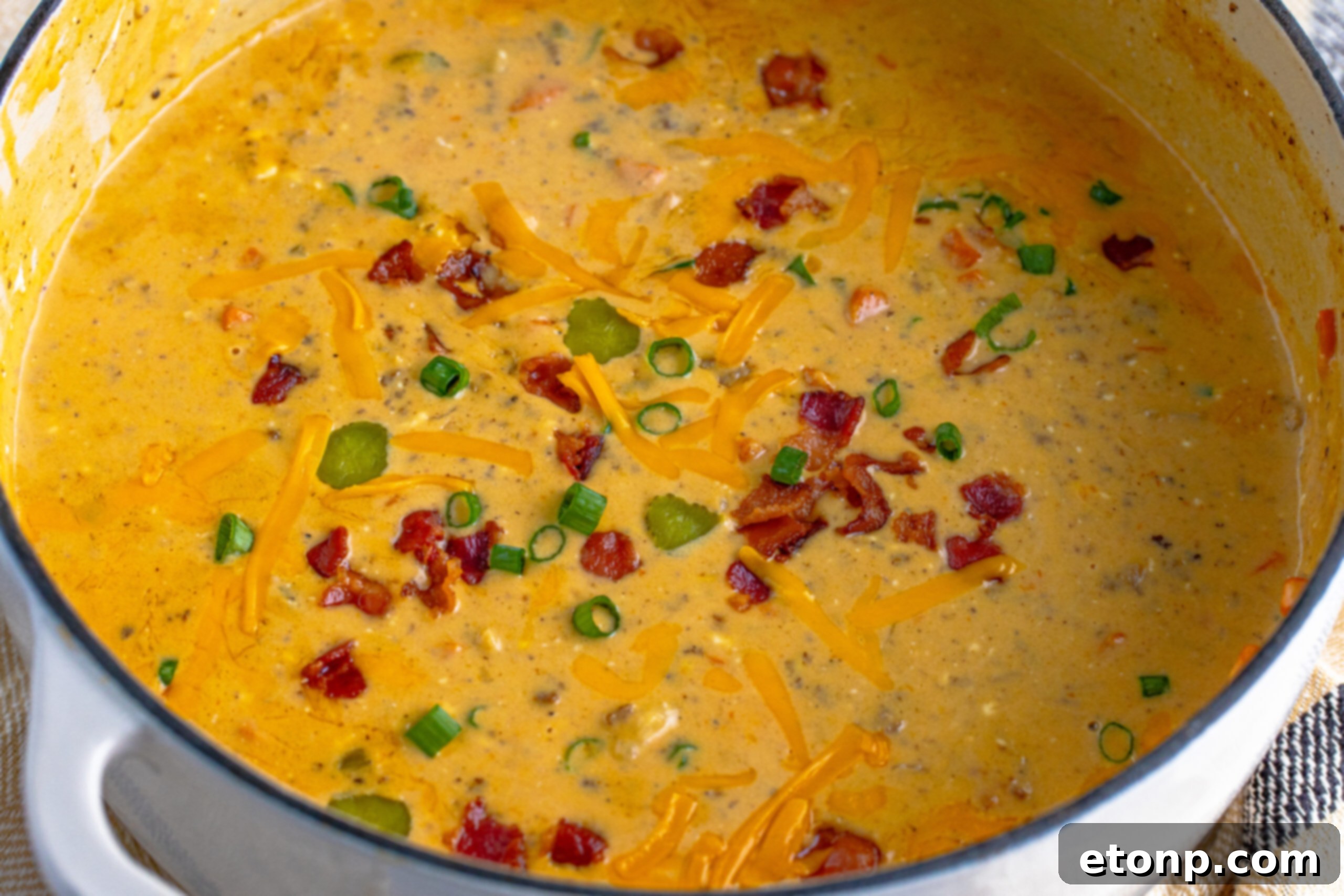Bacon Cheeseburger Bliss in a Bowl 5 white dutch oven pot filled with Bacon Cheeseburger Soup topped with sprinkled bacon pieces