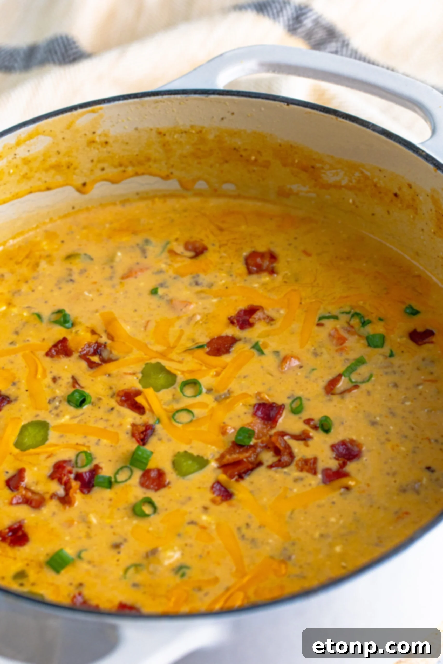 Bacon Cheeseburger Bliss in a Bowl 8 white dutch oven pot filled with Bacon Cheeseburger Soup topped with sprinkled bacon pieces