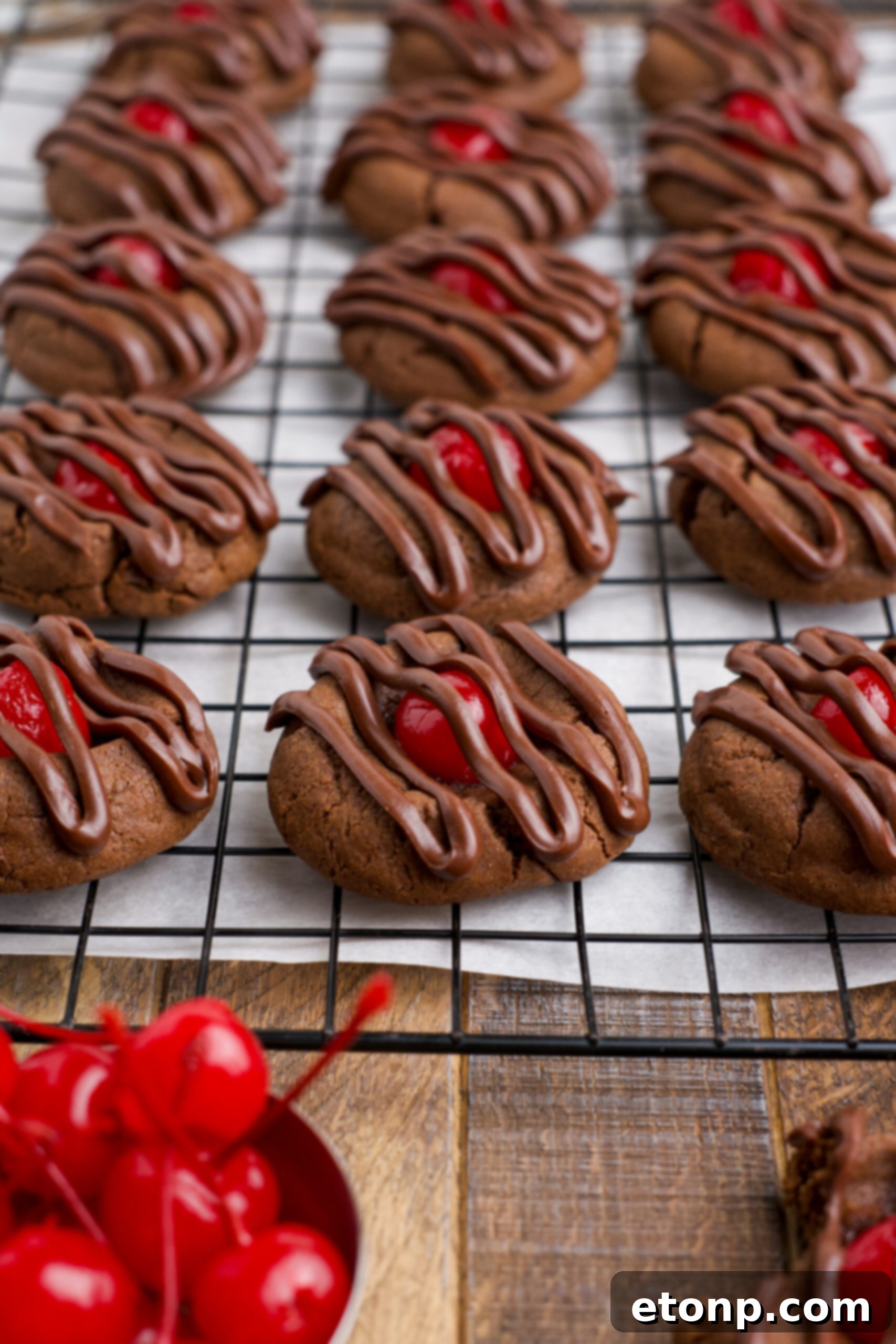 A cooling rack filled with freshly baked Chocolate Cherry Cookies, each adorned with a delicate drizzle of melted chocolate, promising a rich and satisfying flavor profile.