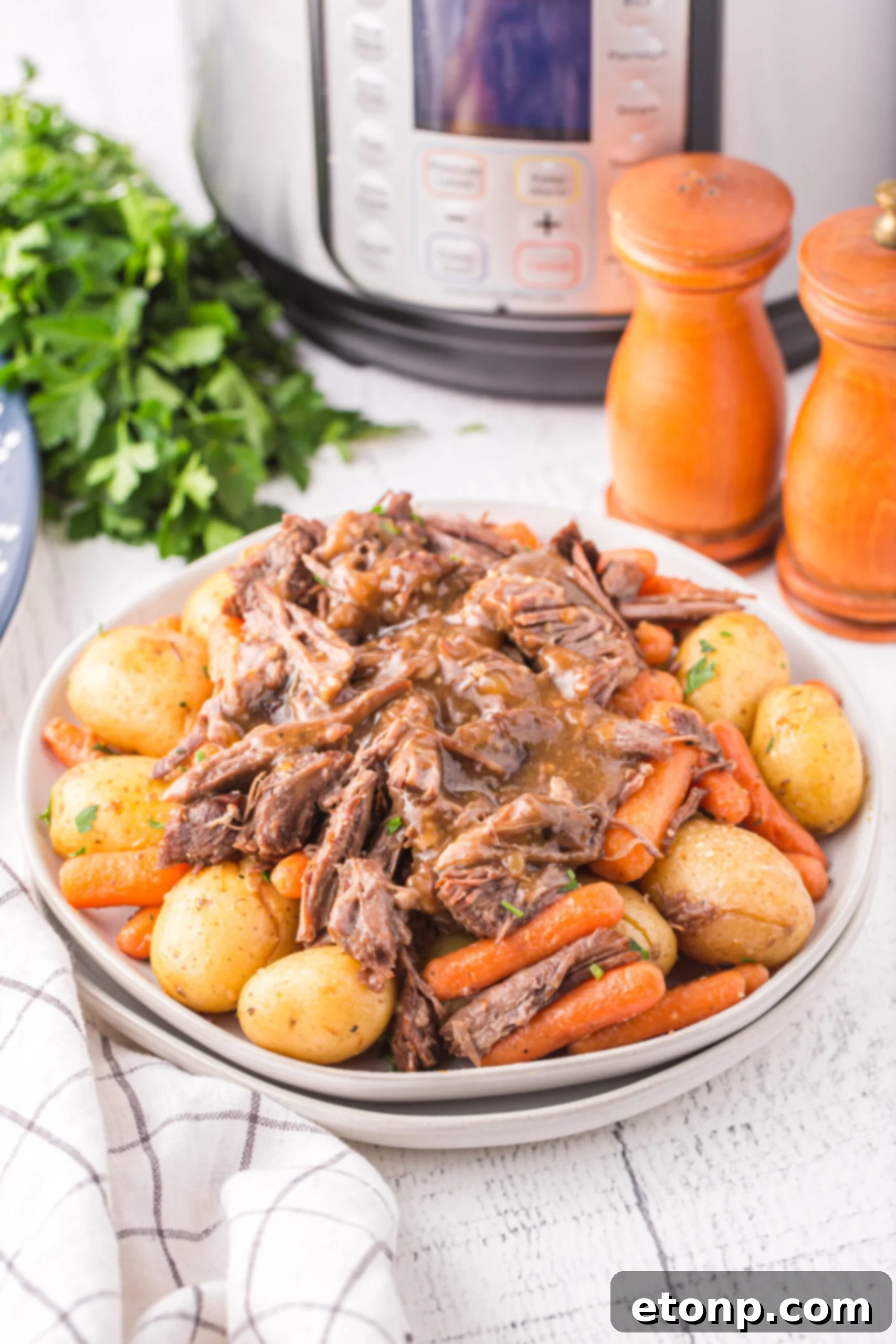 Instant Pot Pot Roast with potatoes and carrots on a white plate. 