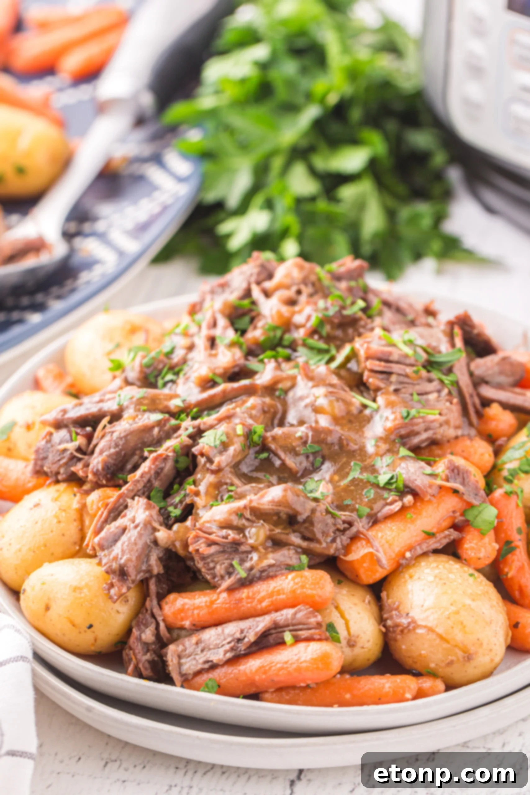 Instant Pot Pot Roast with potatoes and carrots on a white plate. 