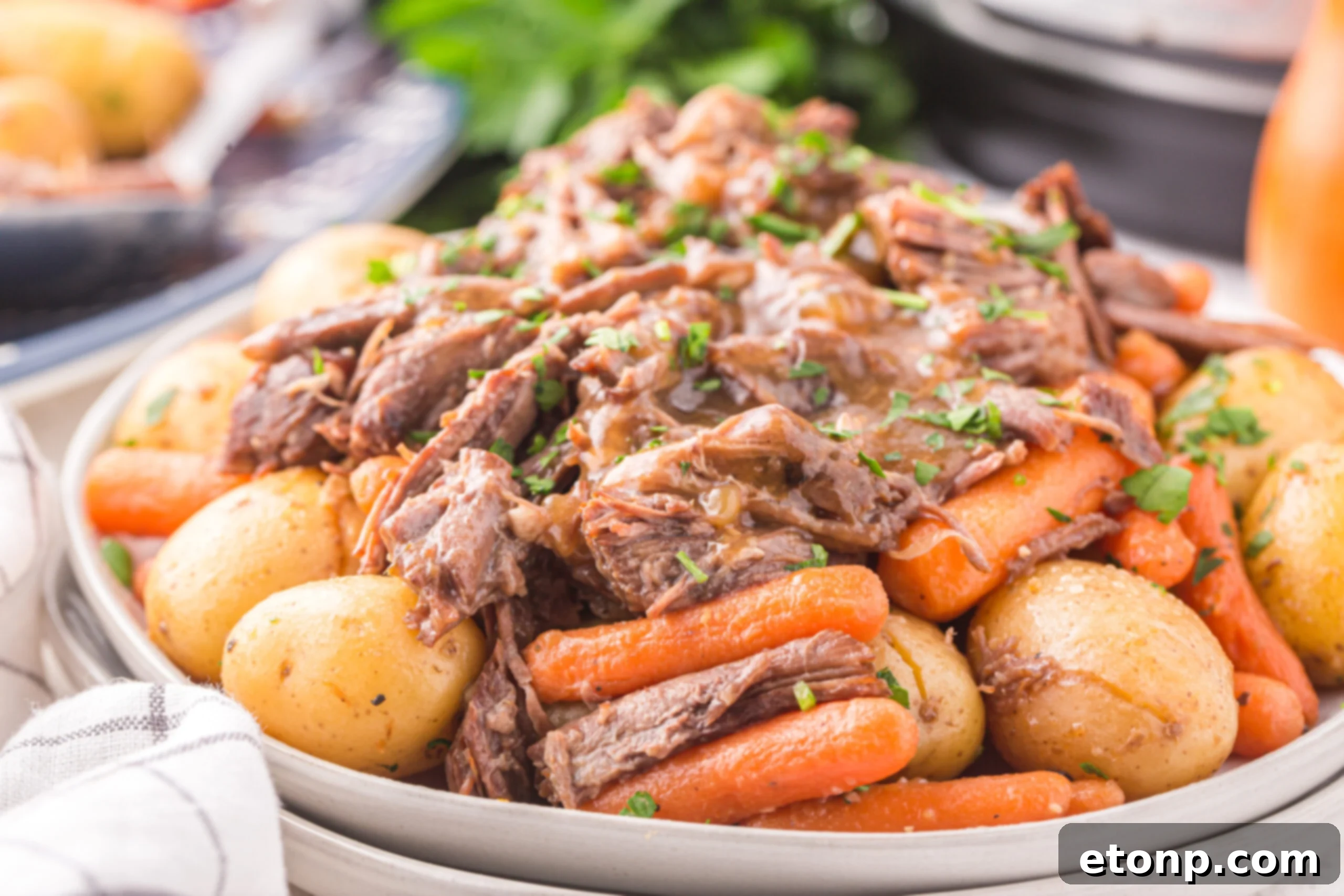 a white plate of instant pot pot roast  with carrots and potatoes 