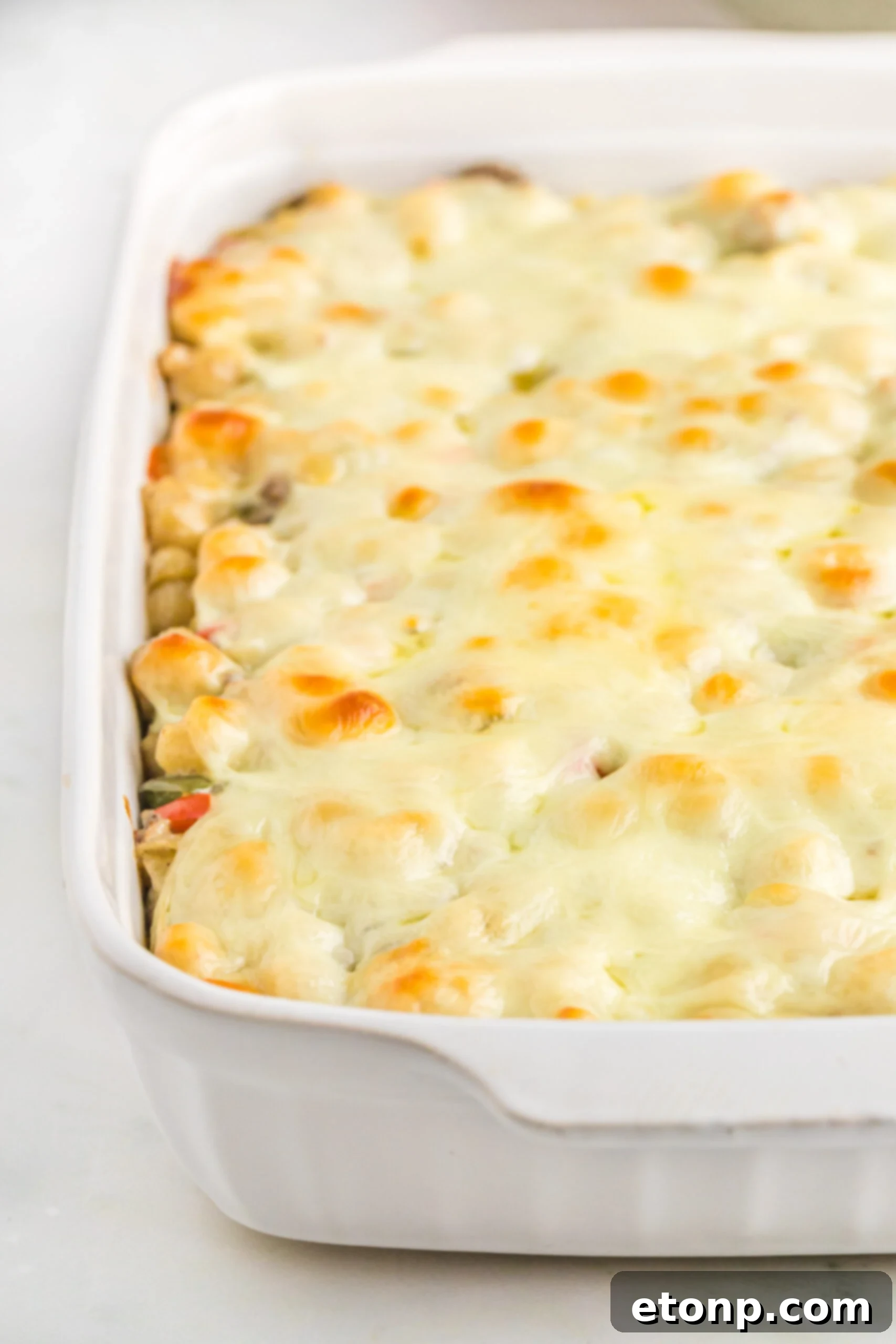 Up close view of Philly Cheesesteak Casserole in a white baking dish.