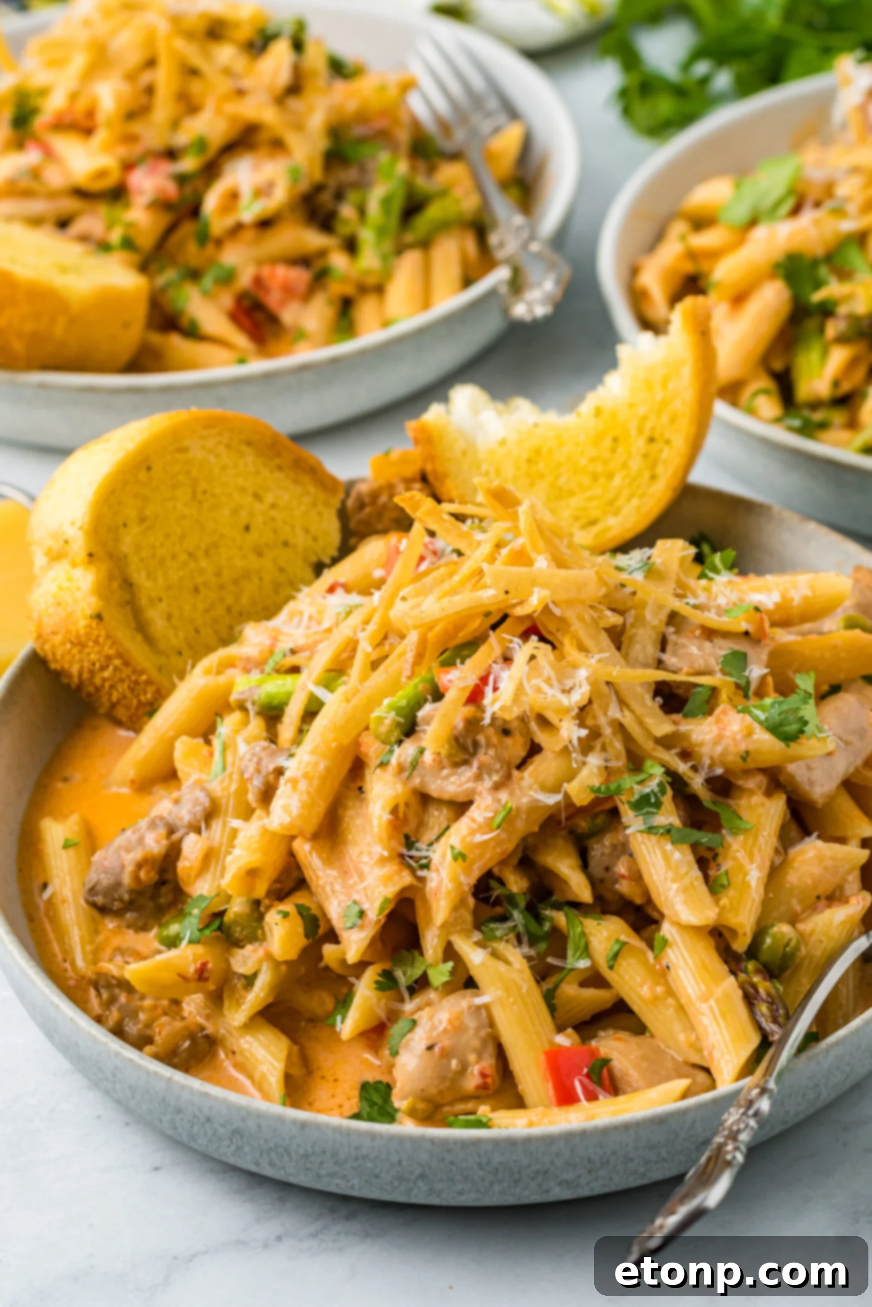 Side view of Cajun Chicken Pasta served in a dish with garlic bread.