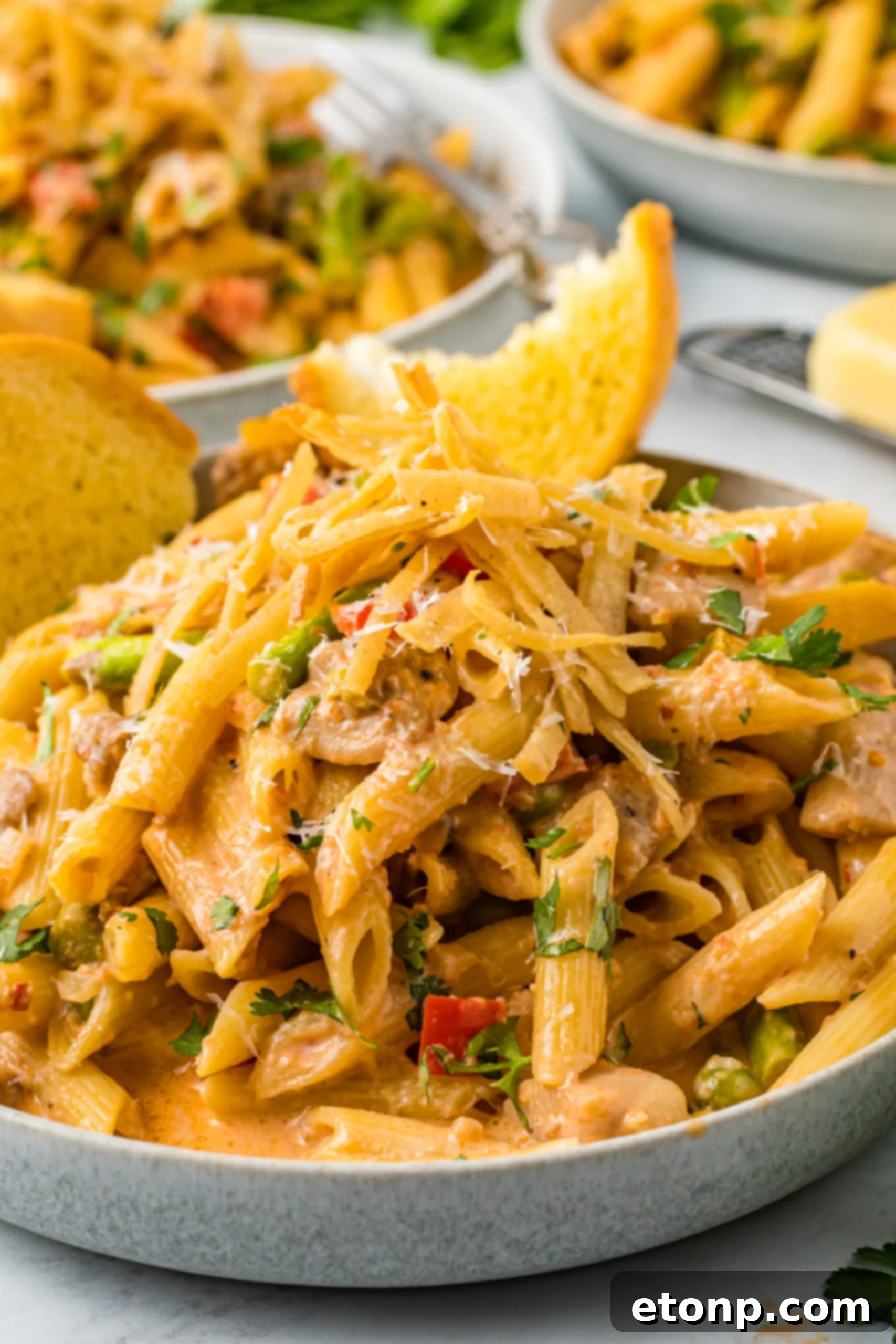 Cloe up view of Cajun Chicken Pasta served in a dish with garlic bread.
