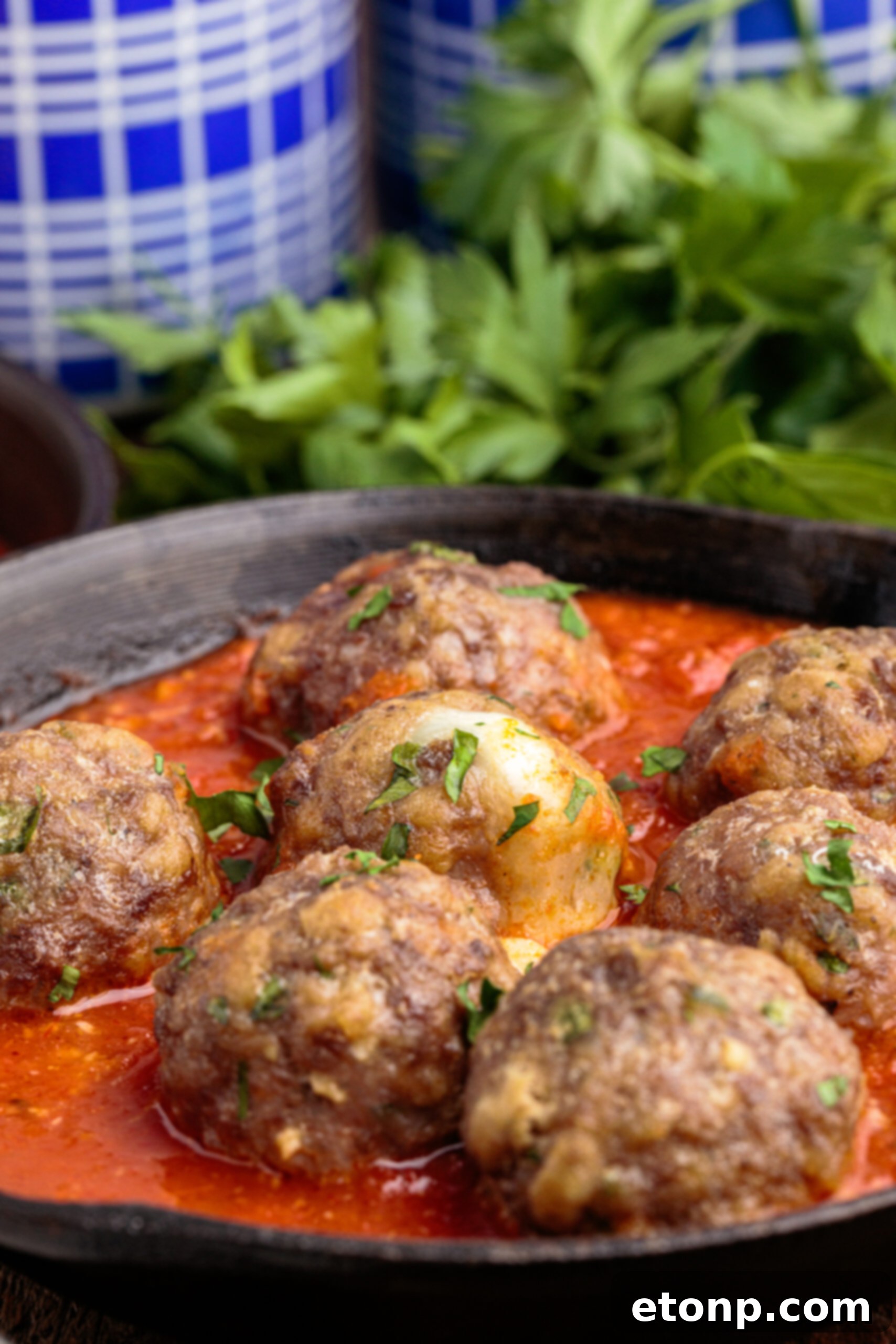 Gooey Mozzarella Meatballs 5 Side view of freshly cooked Mozzarella Stuffed Meatballs resting in a seasoned cast iron skillet, ready to be served.
