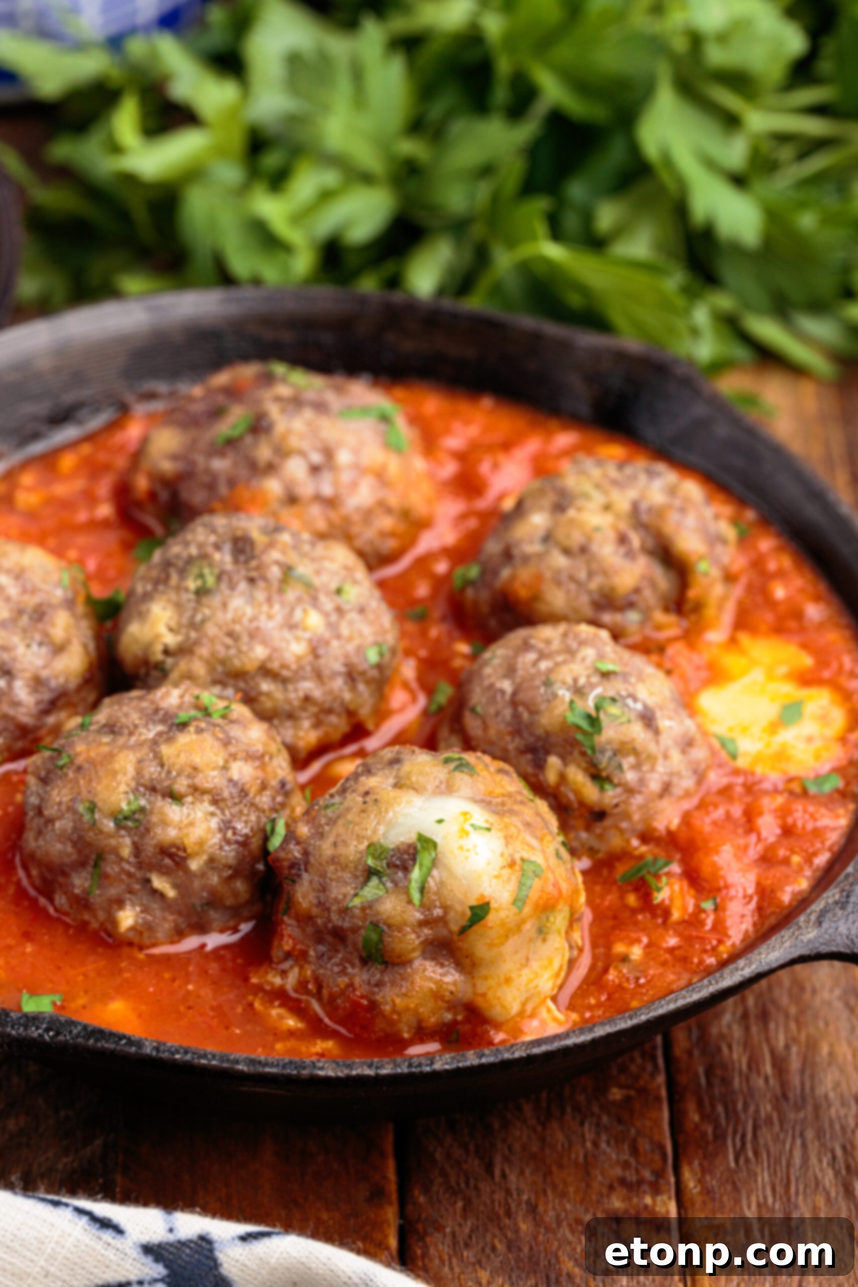 Gooey Mozzarella Meatballs 6 Side view of perfectly baked Mozzarella Stuffed Meatballs in a black cast iron skillet.