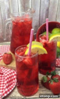 A close-up of a glass of Southern Strawberry Sweet Tea with ice.