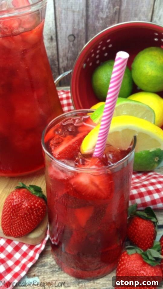 A stunning final shot of Southern Strawberry Sweet Tea in a pitcher and glasses, garnished for serving.