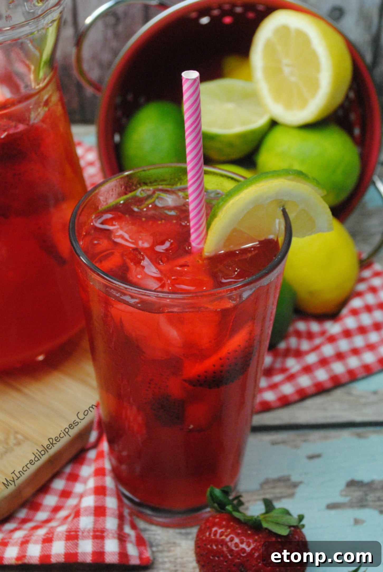A large pitcher of Southern Strawberry Sweet Tea being poured into a glass.