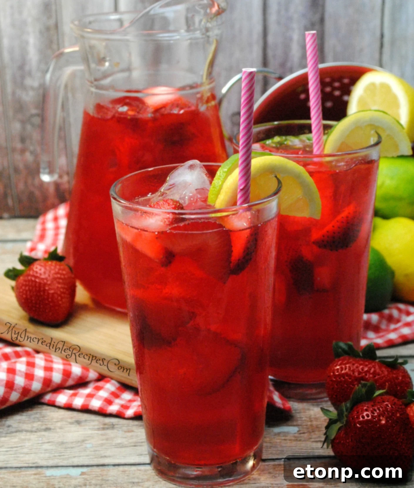 Three glasses of Southern Strawberry Sweet Tea garnished with fresh mint and strawberry slices.