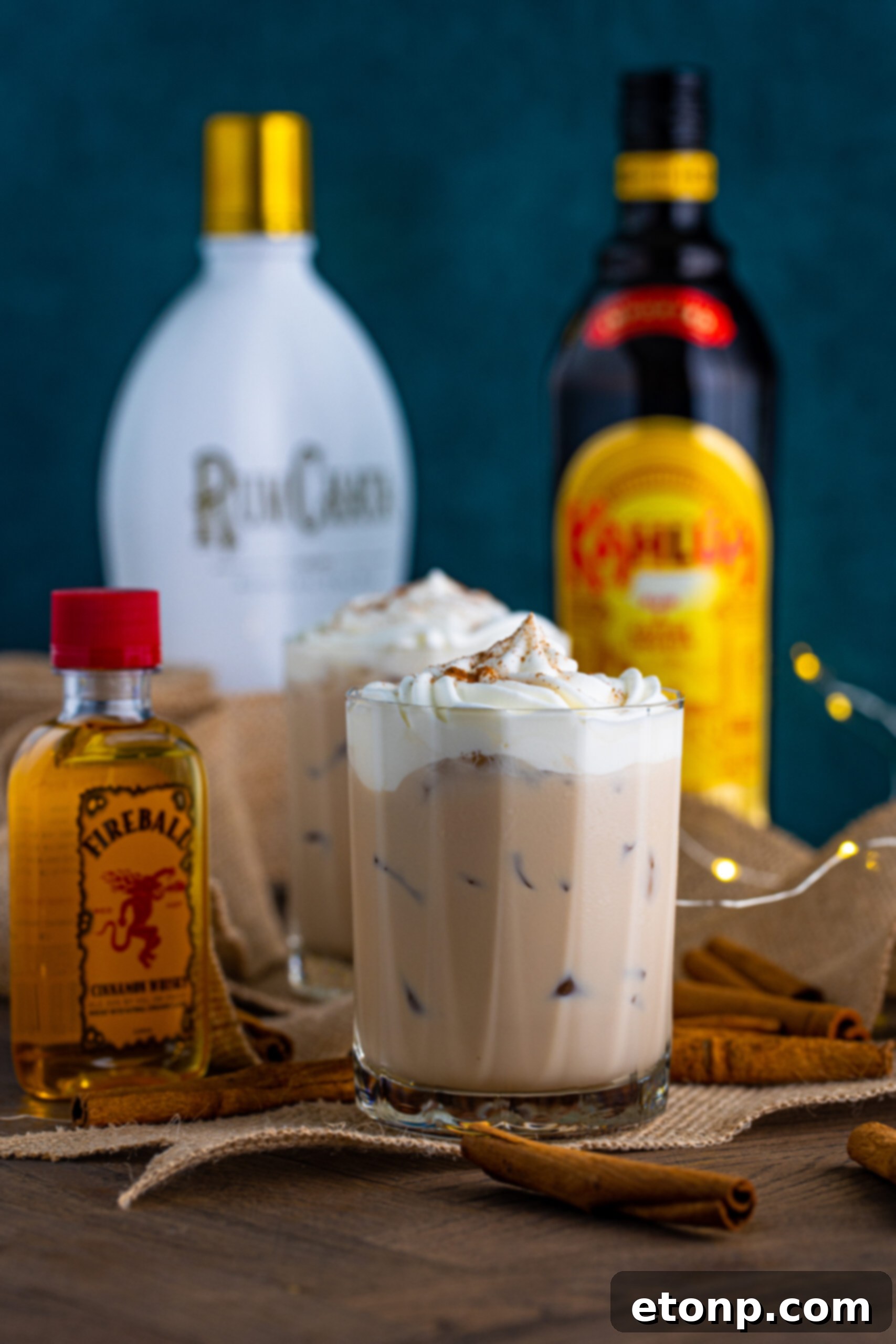Front view of Cinnamon Roll Cocktail surrounded by cinnamon sticks.
