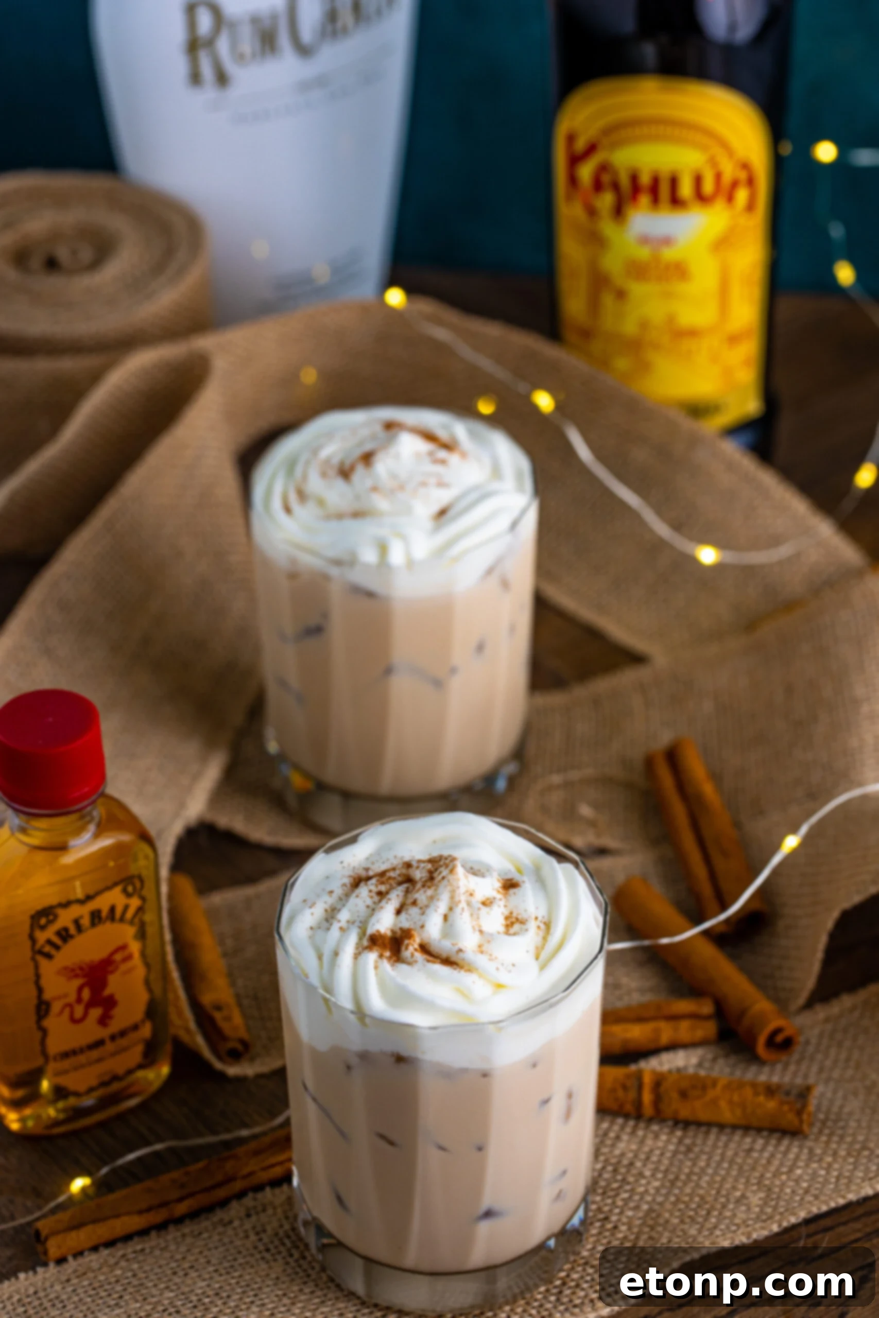 View of Cinnamon Roll Cocktail surrounded with cinnamon sticks.