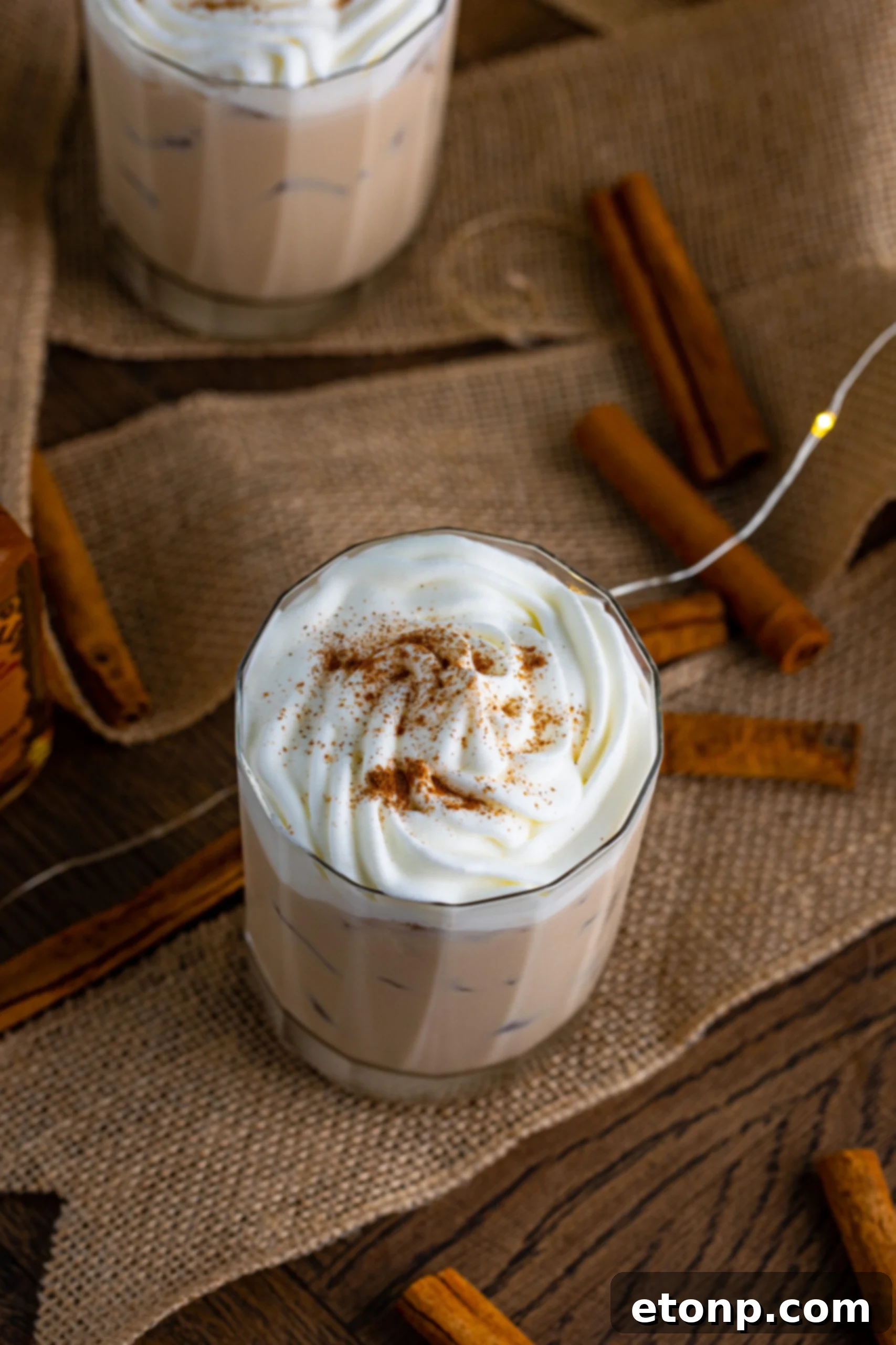 Overhead view of Cinnamon Roll Cocktail Surrounded by cinnamon sticks.