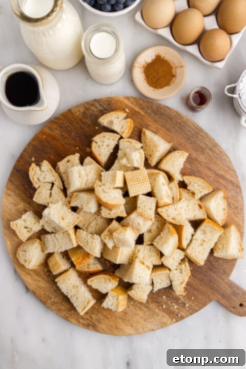 French bread cubes soaking in creamy custard mixture in a bowl.