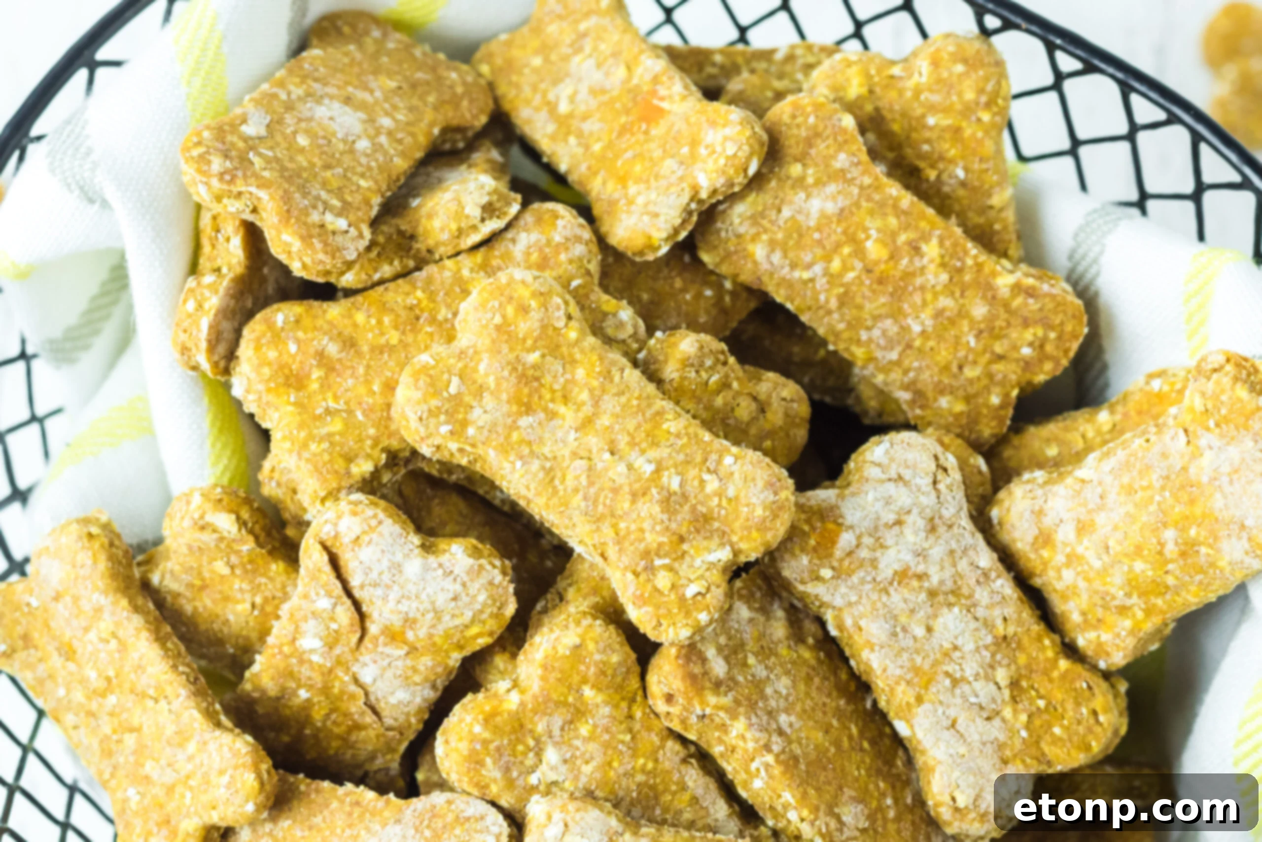 Overhead view of a generous serving of Sweet Potato and Pumpkin Dog Treats artfully arranged in a charming wire basket, perfect for a dog's snack time.