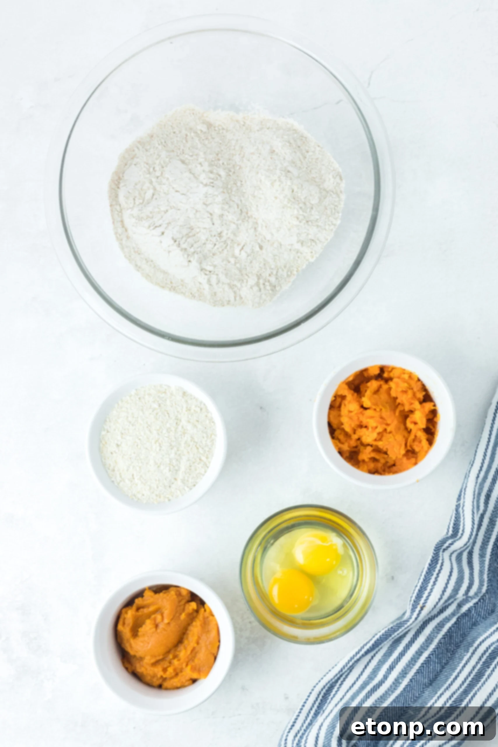 Overhead flat lay shot of all the wholesome ingredients laid out on a clean surface, ready for preparing the Sweet Potato and Pumpkin Dog Treats.