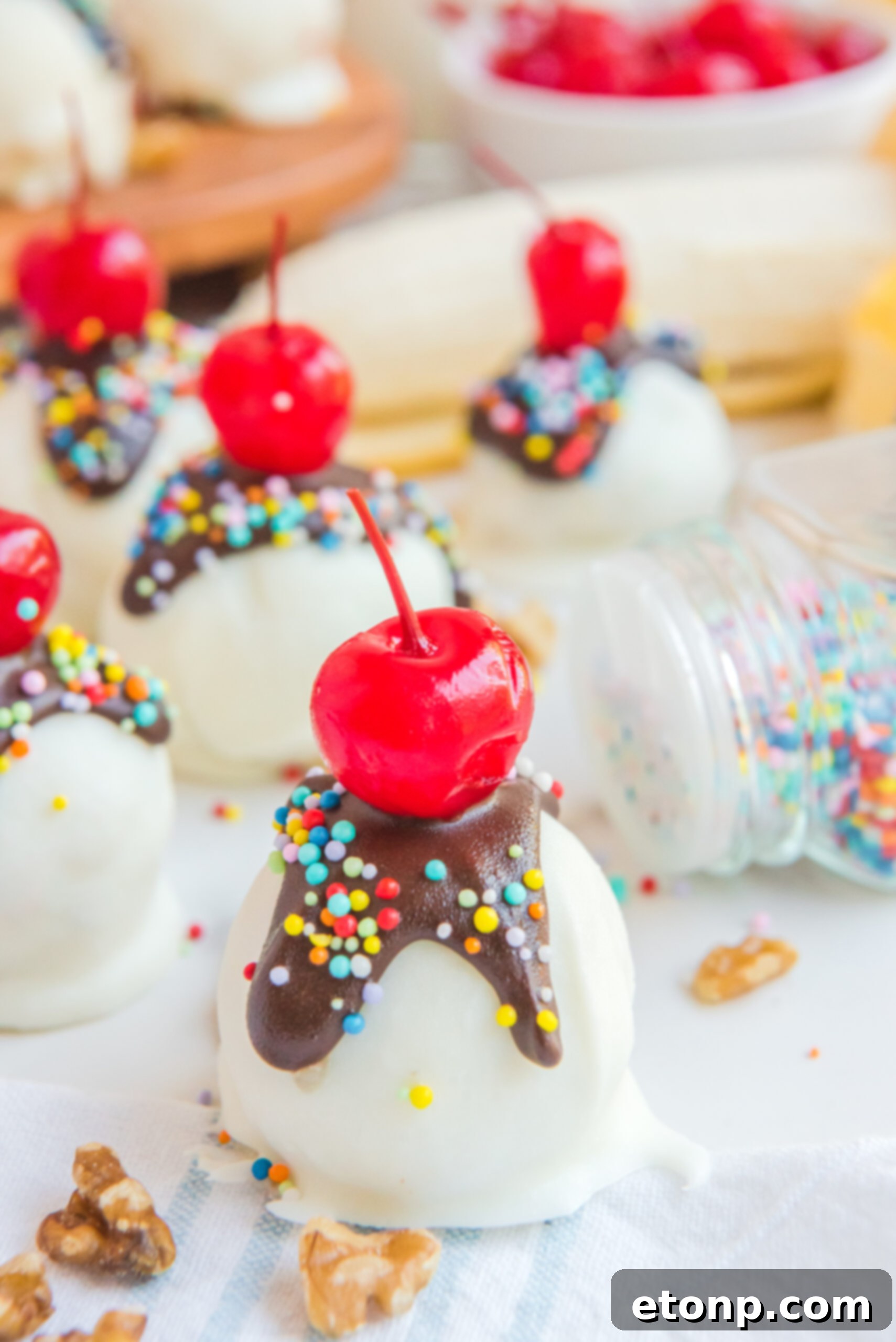 Front view of Banana Truffles surrounded by nuts. and sprinkles