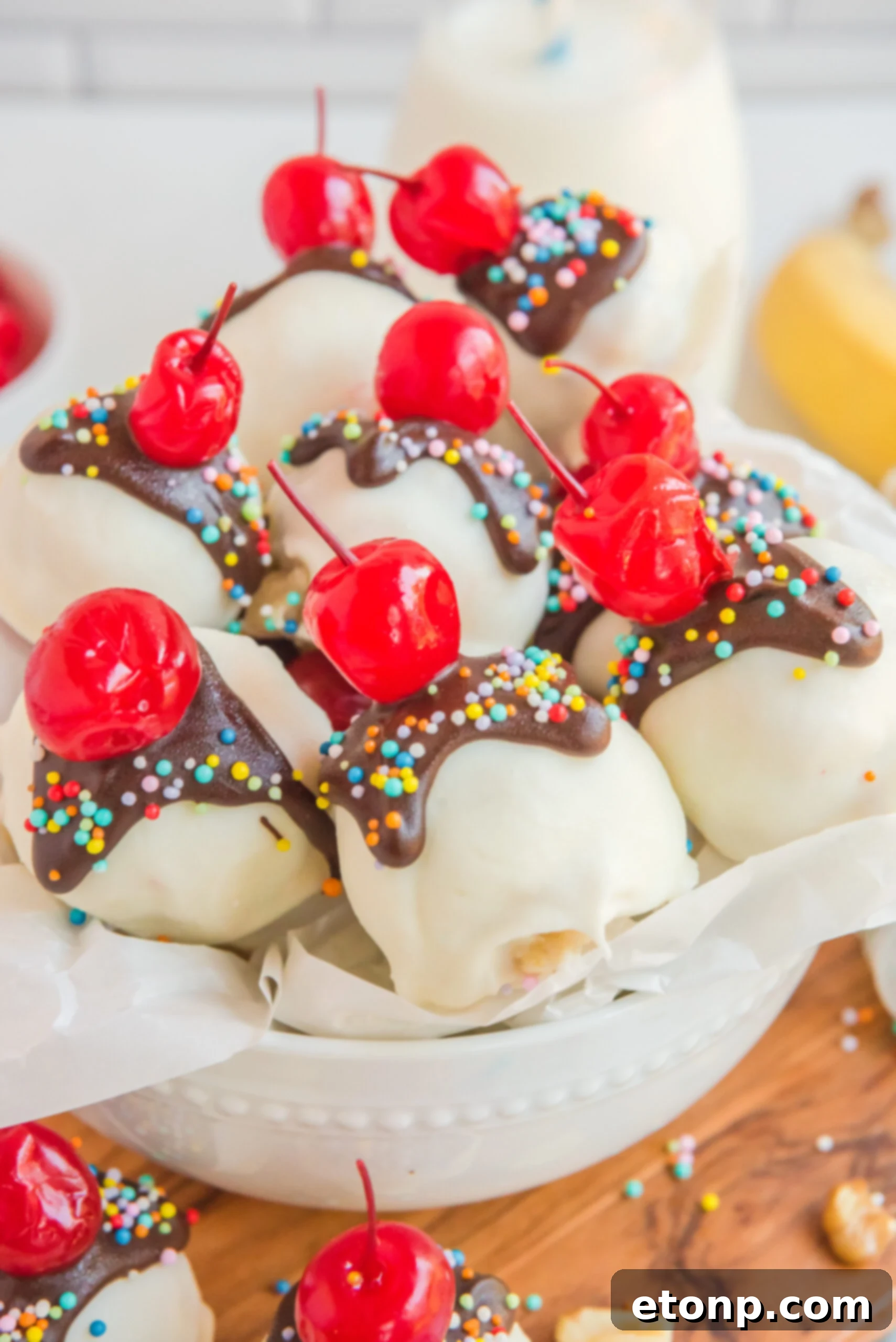 Front view of Banana Truffles stacked in a white dish lined with parchment paper. 