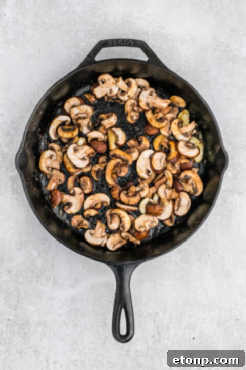 Ultimate Garlic Butter Steak 10 Pouring heavy cream into the mushroom mixture for a rich sauce.