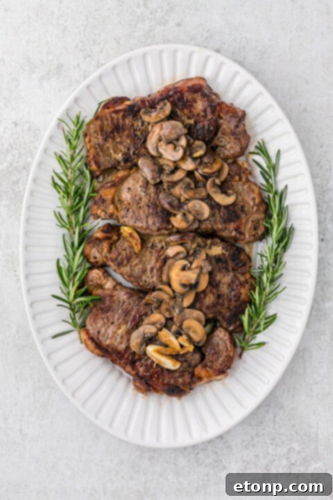 Ultimate Garlic Butter Steak 11 Two cooked steaks resting on a plate, ready to be served.
