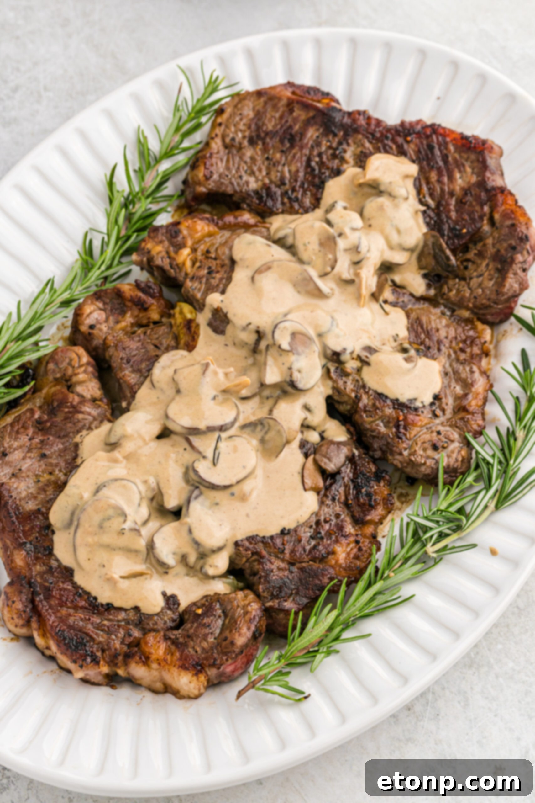 Ultimate Garlic Butter Steak 3 A close-up, inviting shot of a juicy Garlic Butter Steak, sliced and ready to serve, adorned with a creamy mushroom sauce.