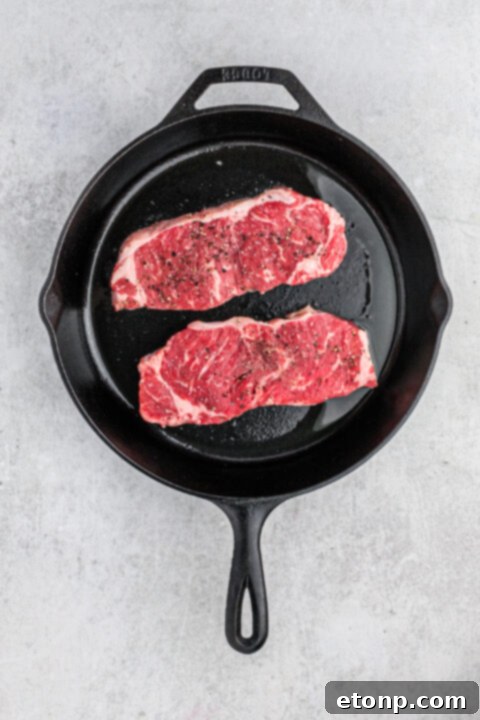 Ultimate Garlic Butter Steak 7 Sizzling steak in a cast iron pan with melting butter and garlic.