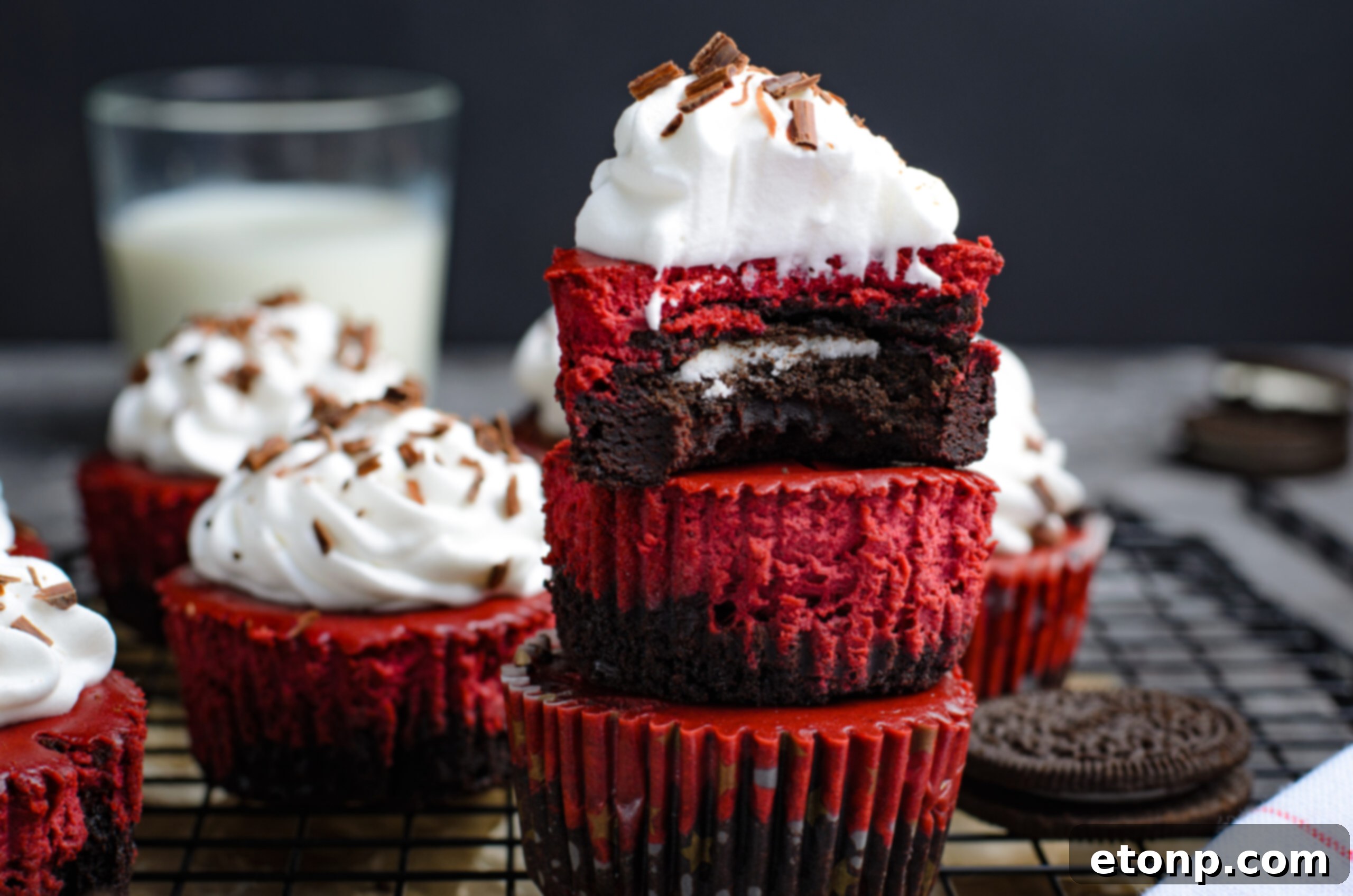 Close up view of Mini Red Velvet Oreo Cheesecakes stacked with a bite missing from the top one