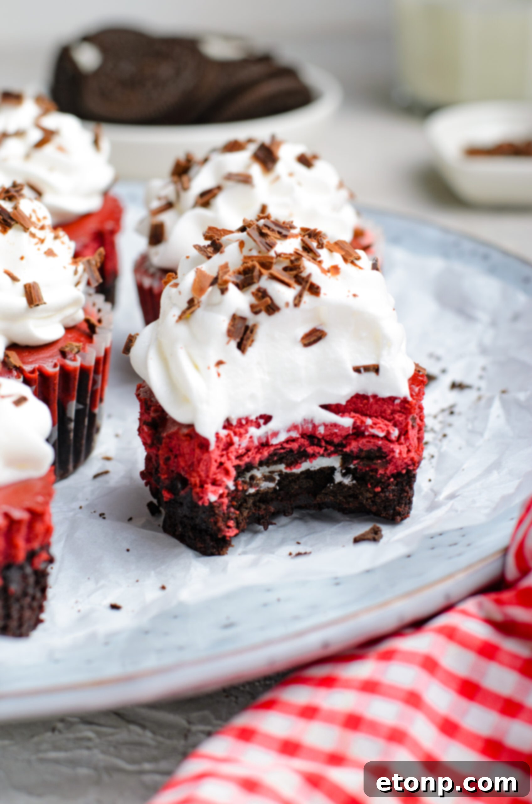 Front view of a Mini Red Velvet Oreo Cheesecake with a bite removed.