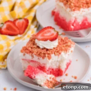 A vibrant Strawberry Crunch Poke Cake with a slice removed.