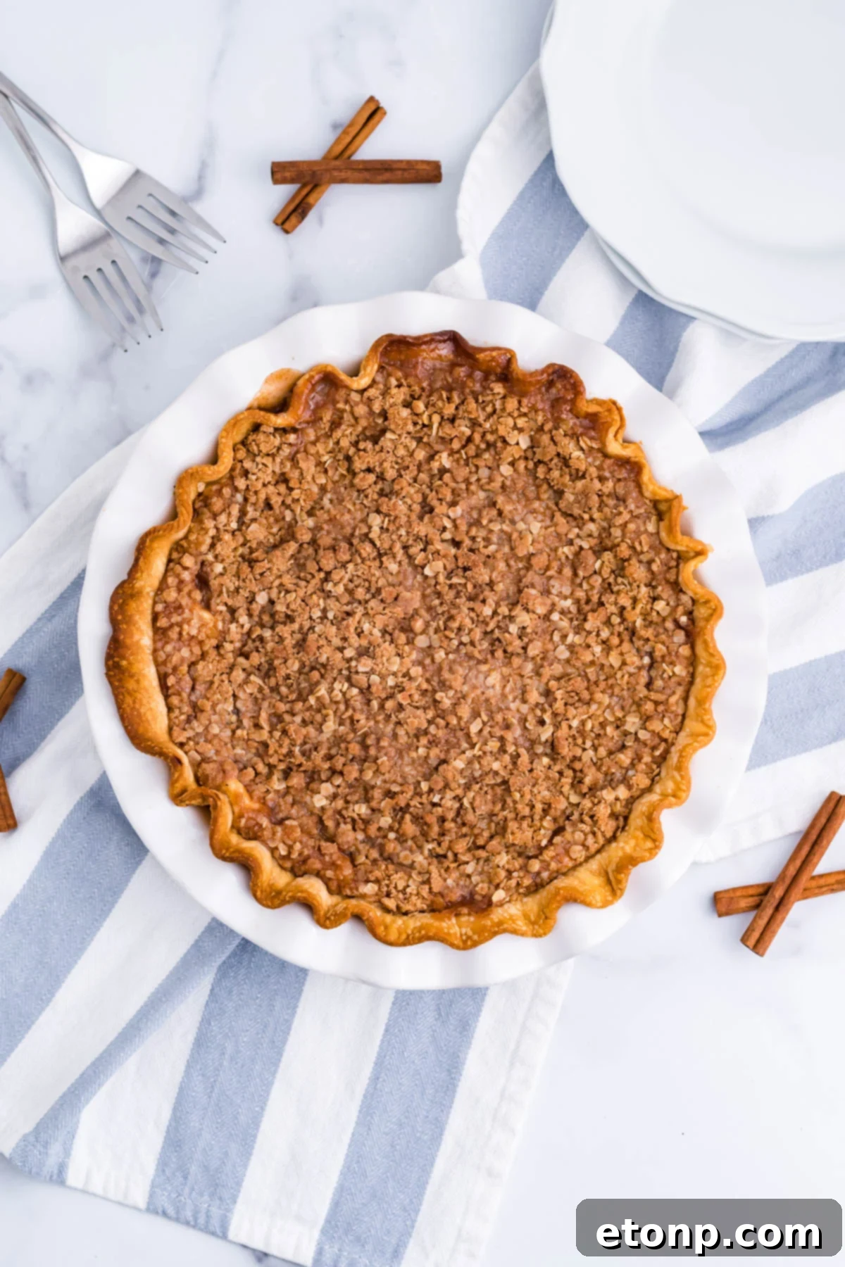 Overhead view of Apple Crumb Cheesecake Pie in a white pie dish.