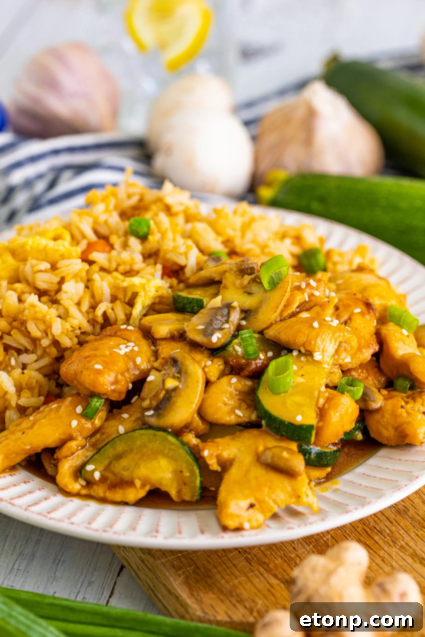 Close up view of Panda Express Mushroom Chicken on a white dish served with fried rice. 